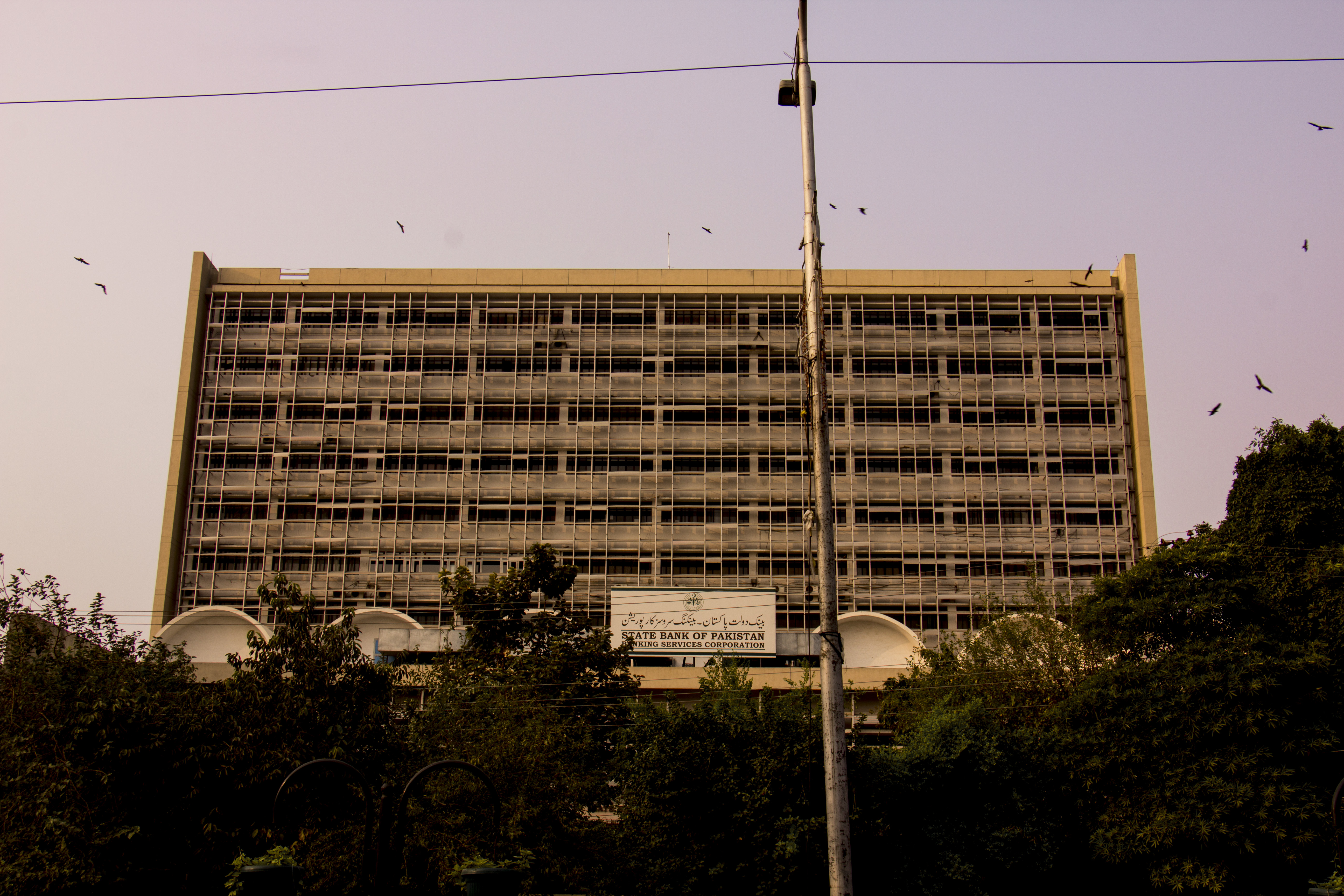 Front facade of the State Bank of Pakistan building in Karachi, a sandstone-and-marble institutional structure under a clear sky.