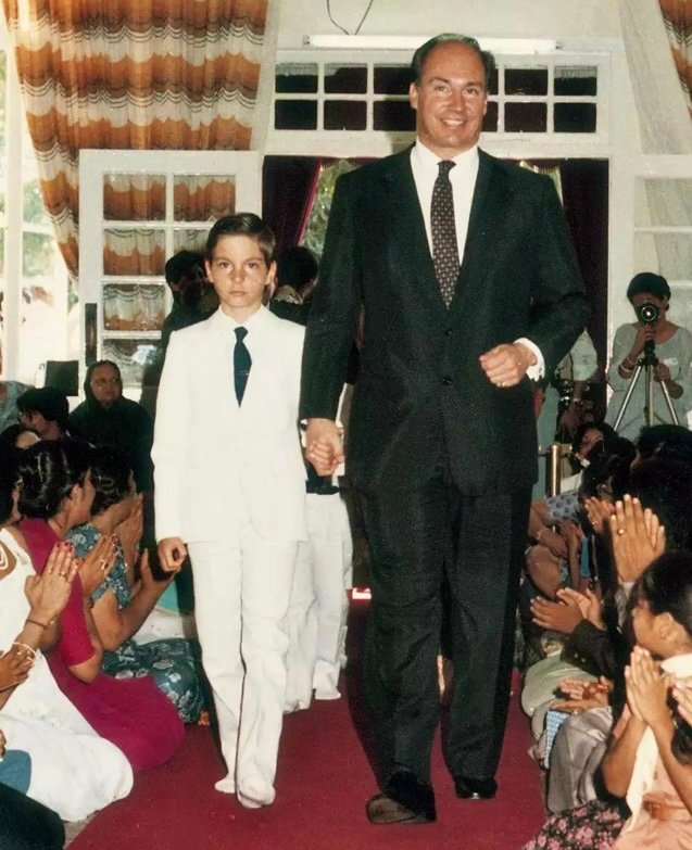 Prince Rahim al-Hussaini, Aga Khan V, in a dark suit and tie, photographed against a plain background.