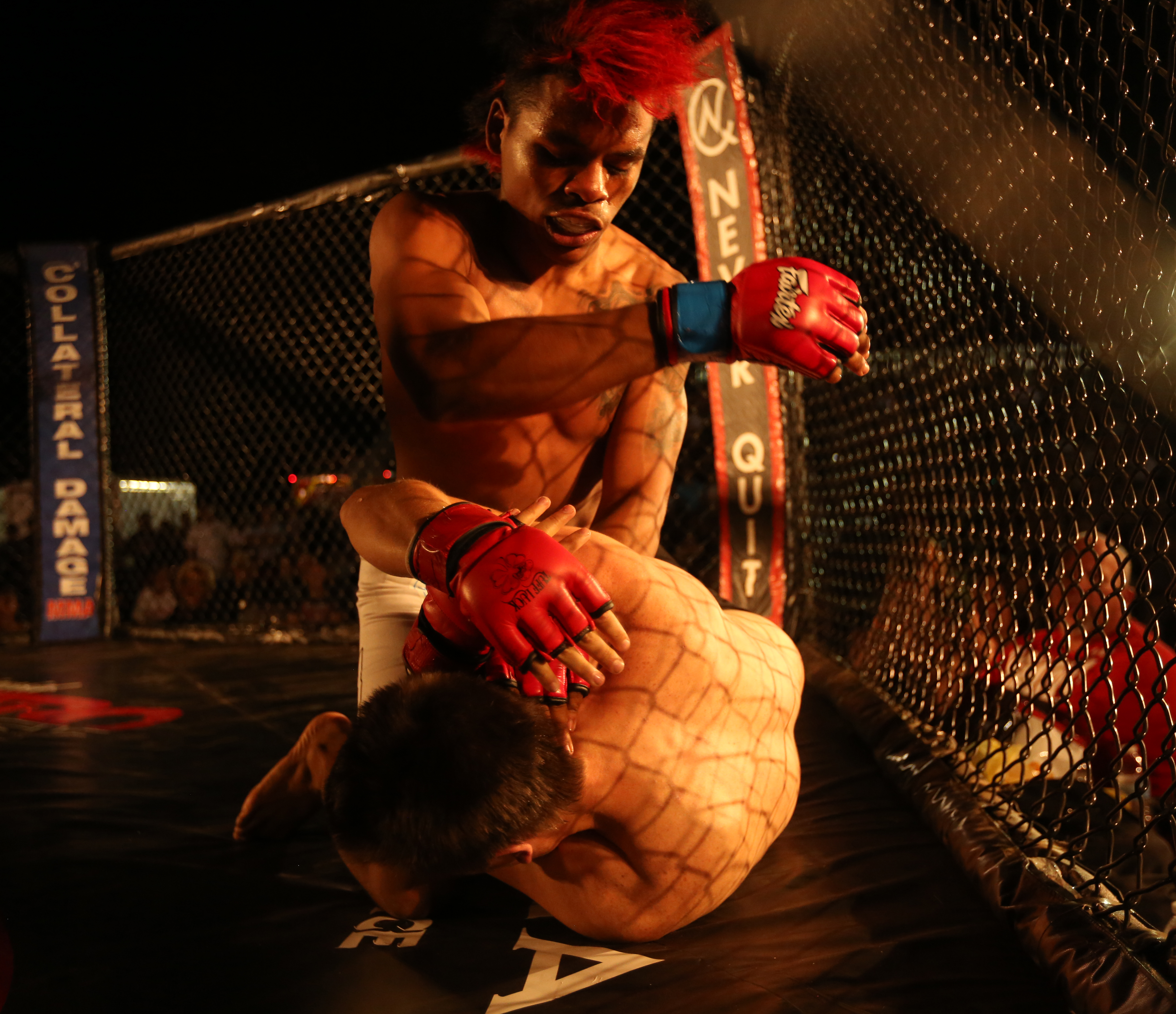Two mixed martial arts fighters competing inside a boxing-style ring, one throwing a strike toward the other