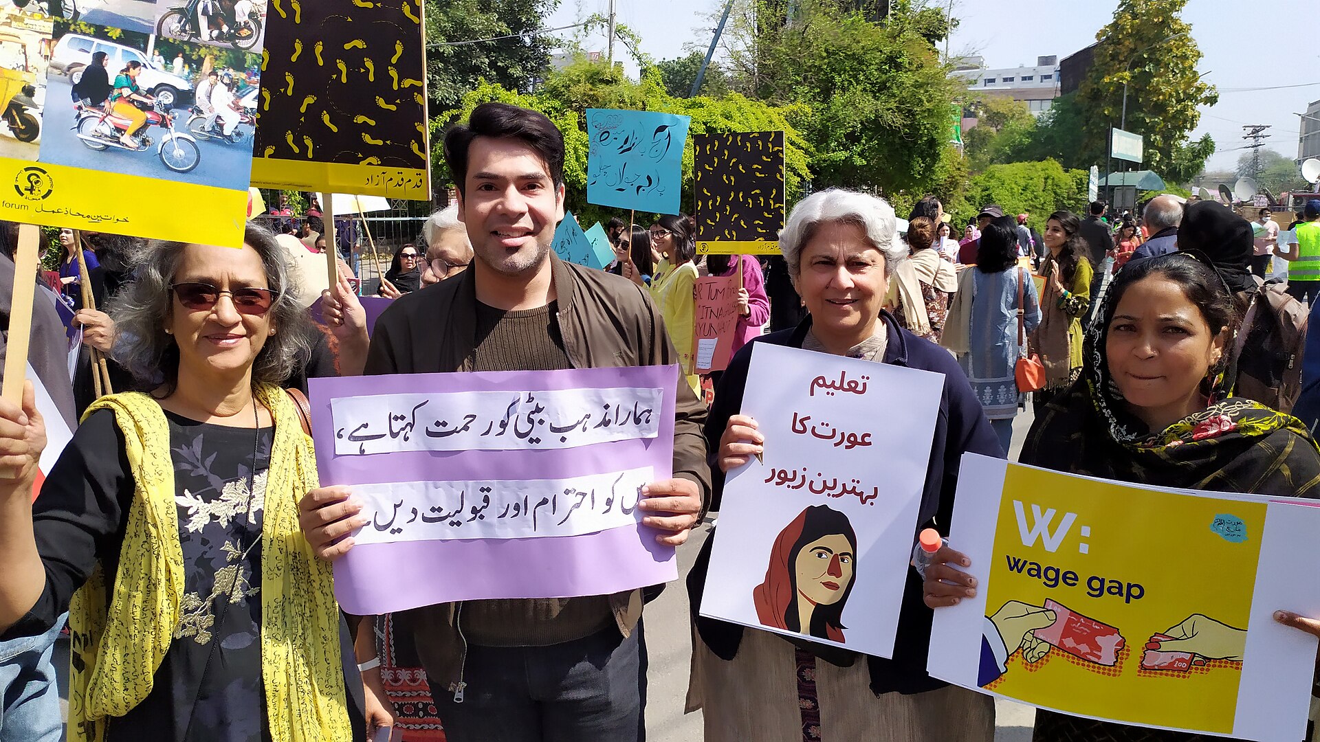 Marchers holding placards during an Aurat March procession in Pakistan.