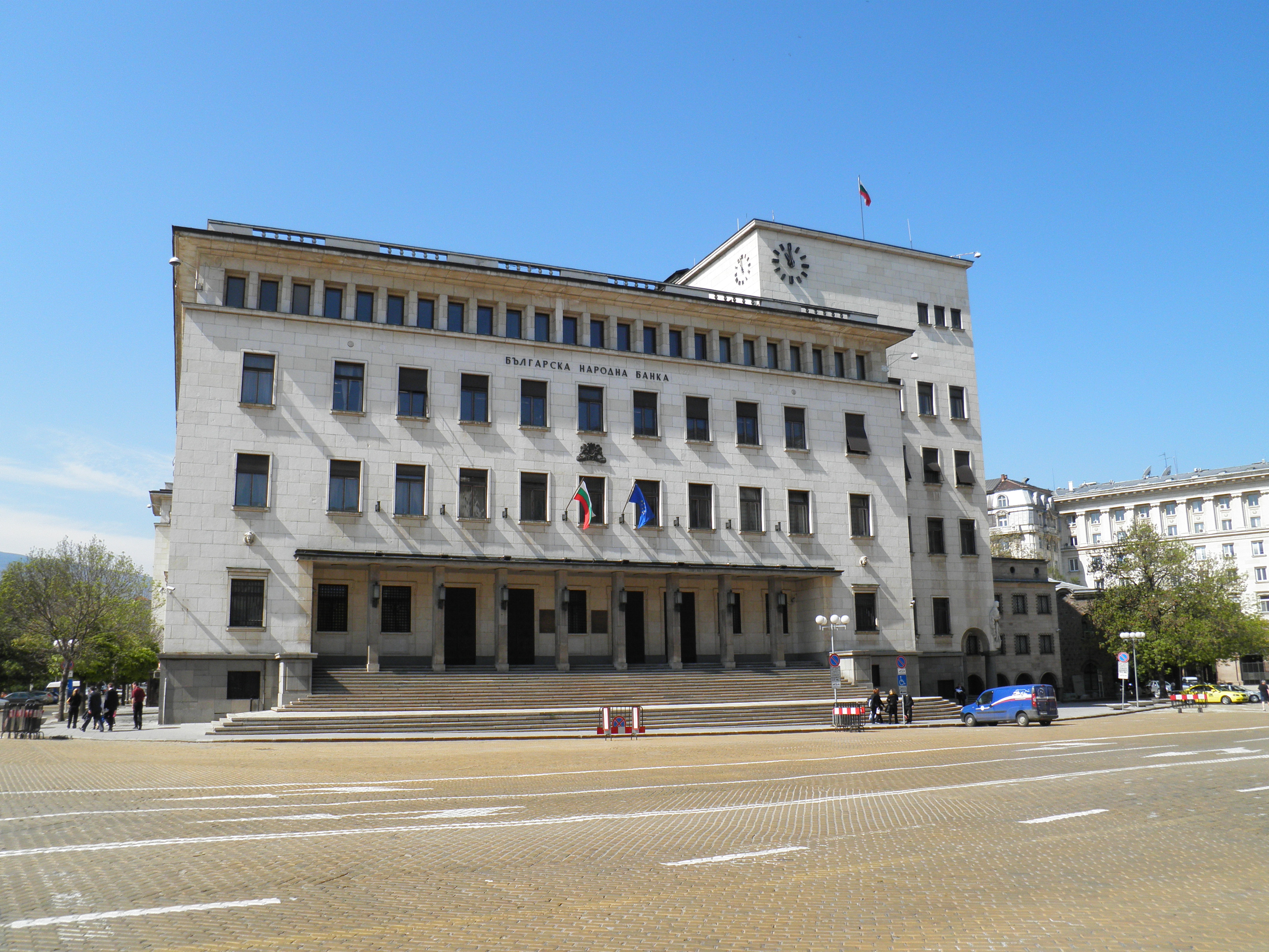 Stone facade of the Bulgarian National Bank in Sofia with Bulgarian and European Union flags above the entrance