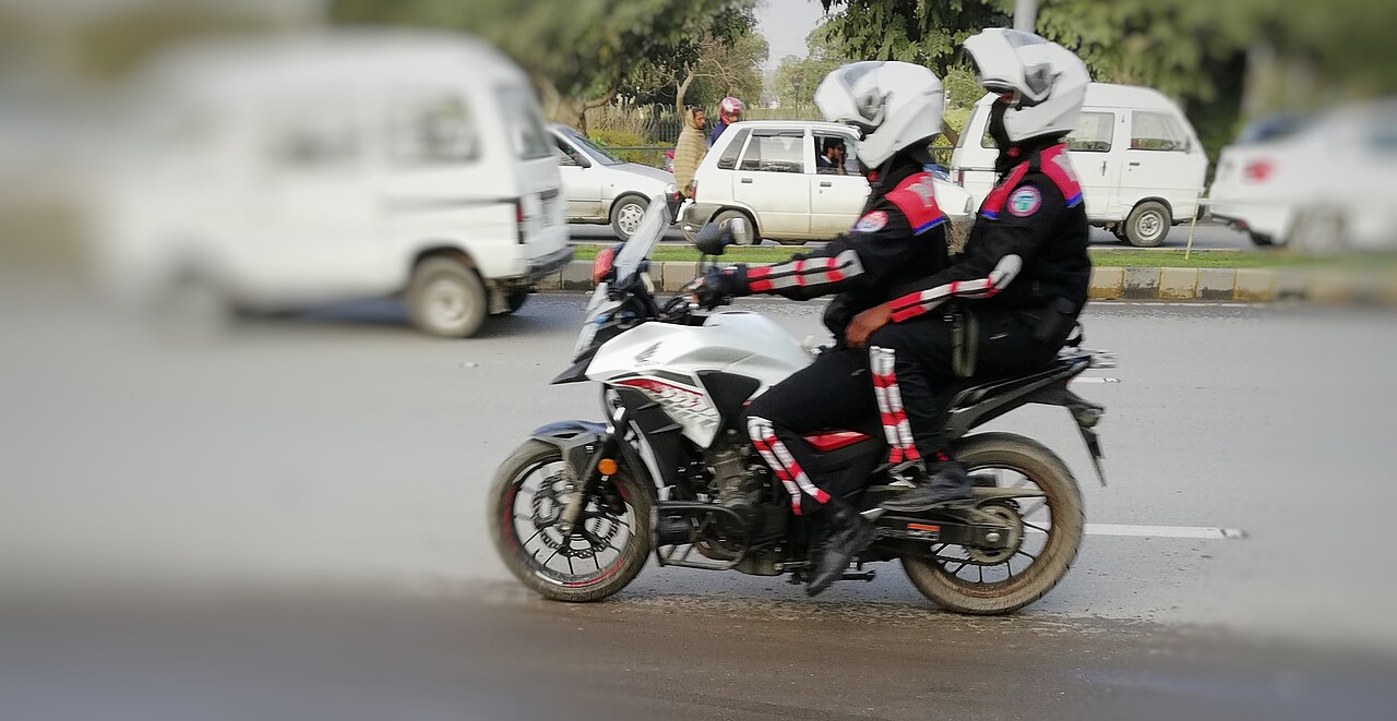Punjab Police Dolphin Force officers on motorcycles patrolling city streets.