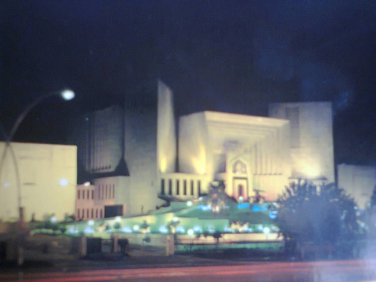 The Supreme Court of Pakistan building in Islamabad illuminated at night.