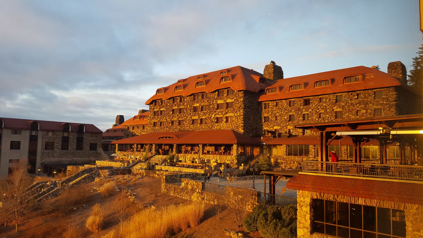 The stone exterior and broad tiled roof of the historic Grove Park Inn in Asheville against a clear sky