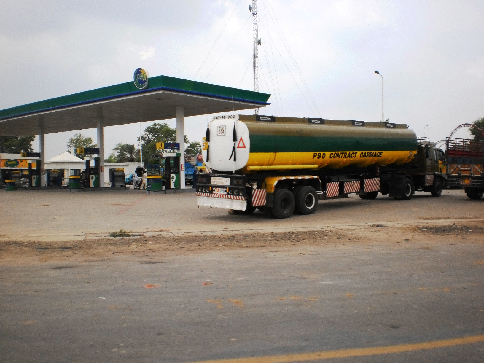 A PSO petrol pump island under a canopy on the Grand Trunk Road in Punjab, with fuel dispensers and price signage