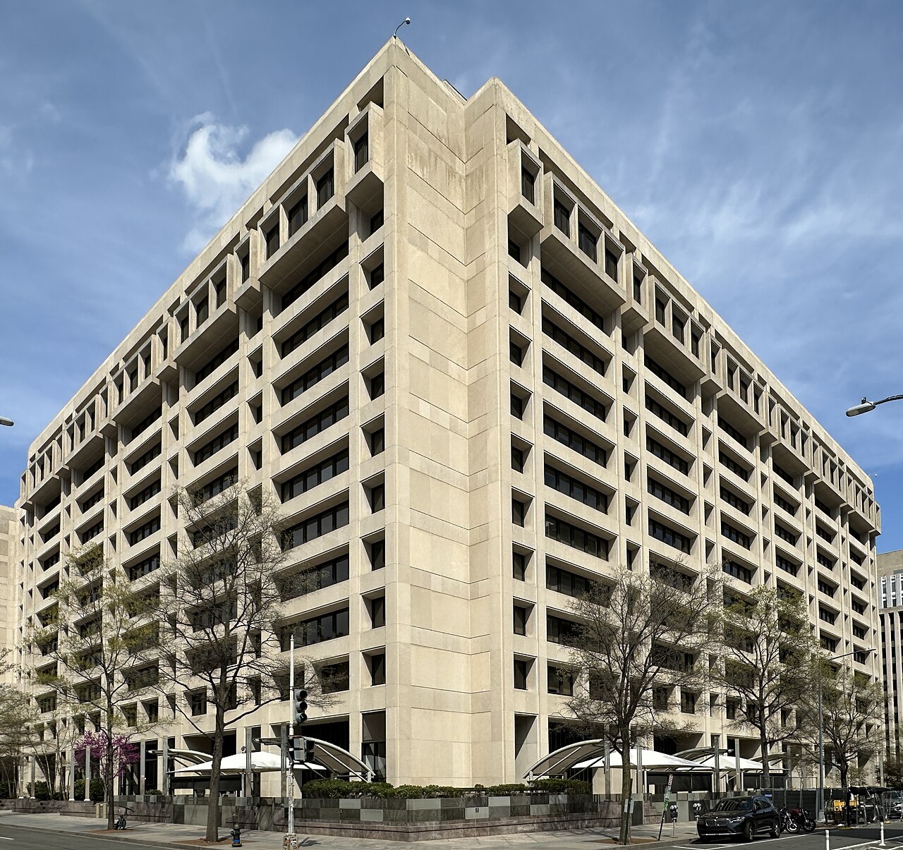 The International Monetary Fund headquarters building in Washington, D.C., seen from the street with flags at the entrance