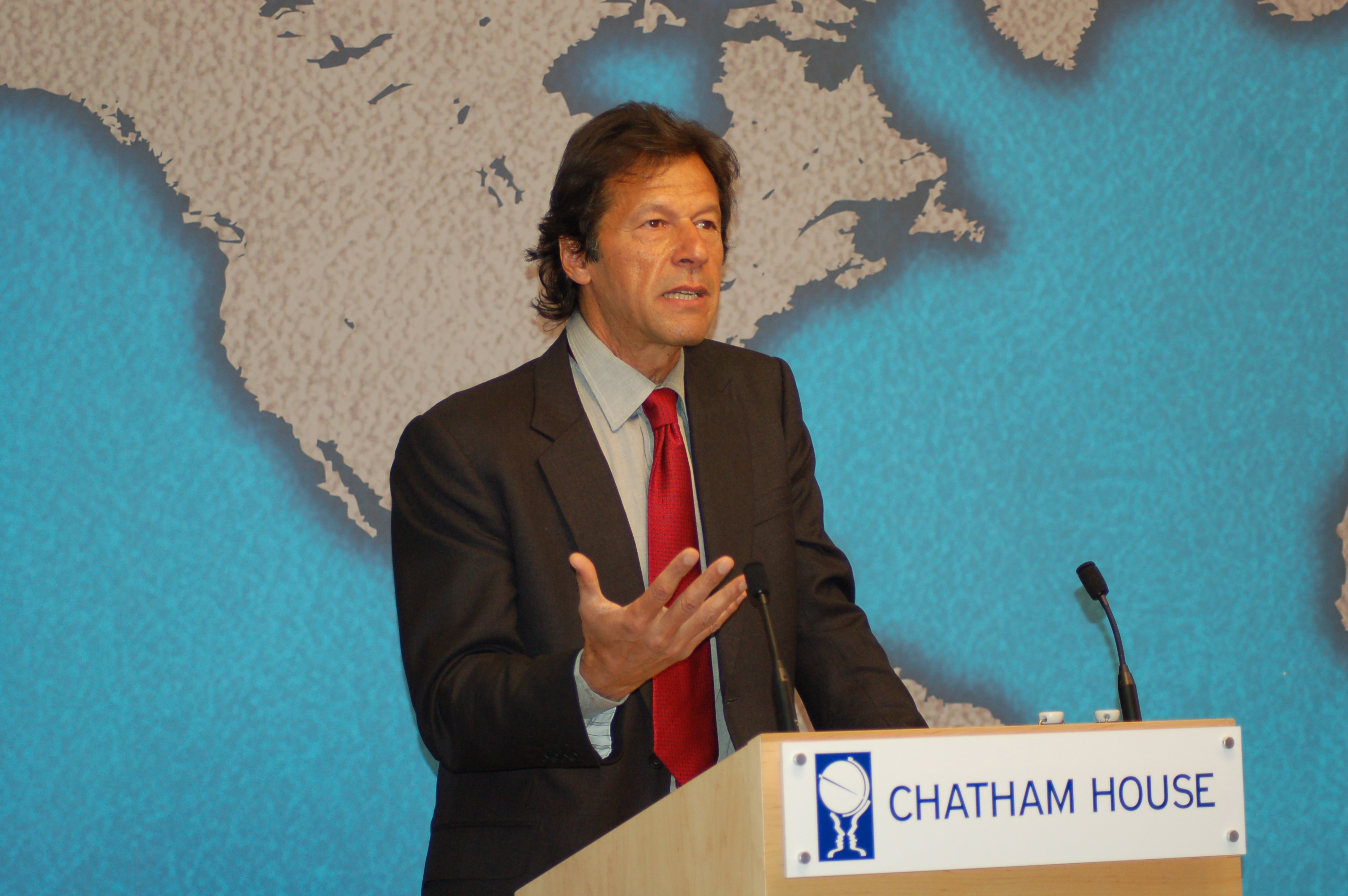 Imran Khan, wearing a dark suit, speaks at a lectern during a 2010 event in London.