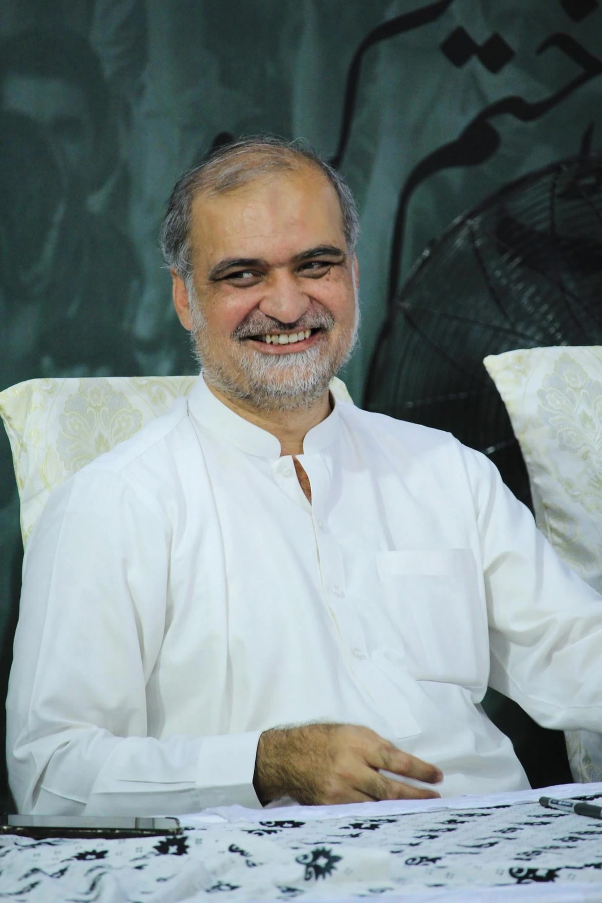 A portrait of Jamaat-i-Islami emir Hafiz Naeemur Rehman wearing glasses and a dark cap.