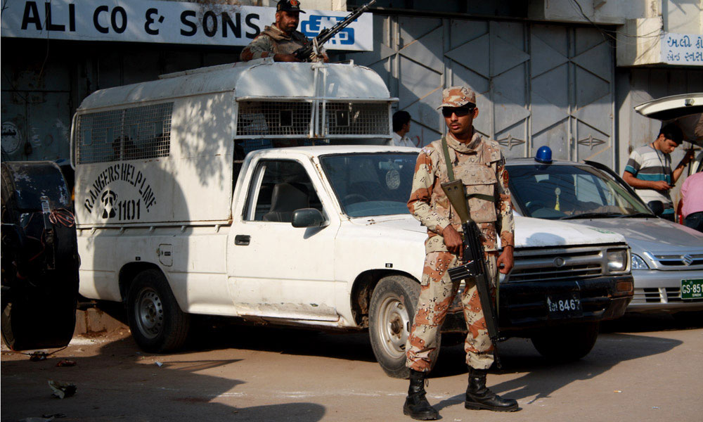 Pakistan Rangers personnel in dark uniforms standing guard on a street in Karachi.