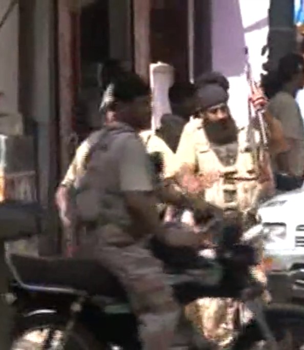 Pakistan Rangers personnel in camouflage uniforms and berets standing in formation.