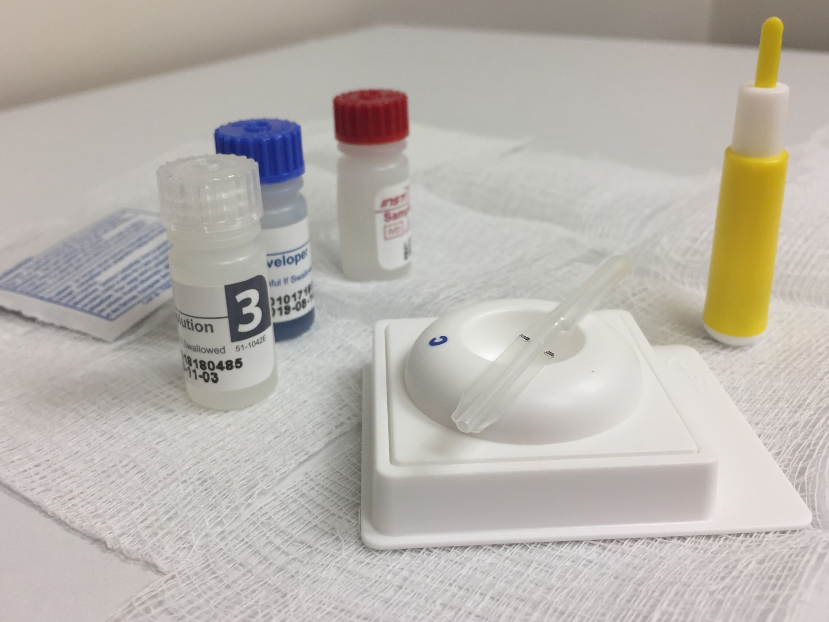 A rapid HIV antibody test kit and its packaging laid out on a surface.