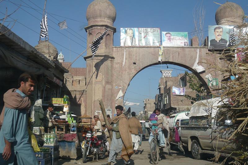 A historic stone gateway framed by shops and traffic in Bannu, Khyber Pakhtunkhwa.