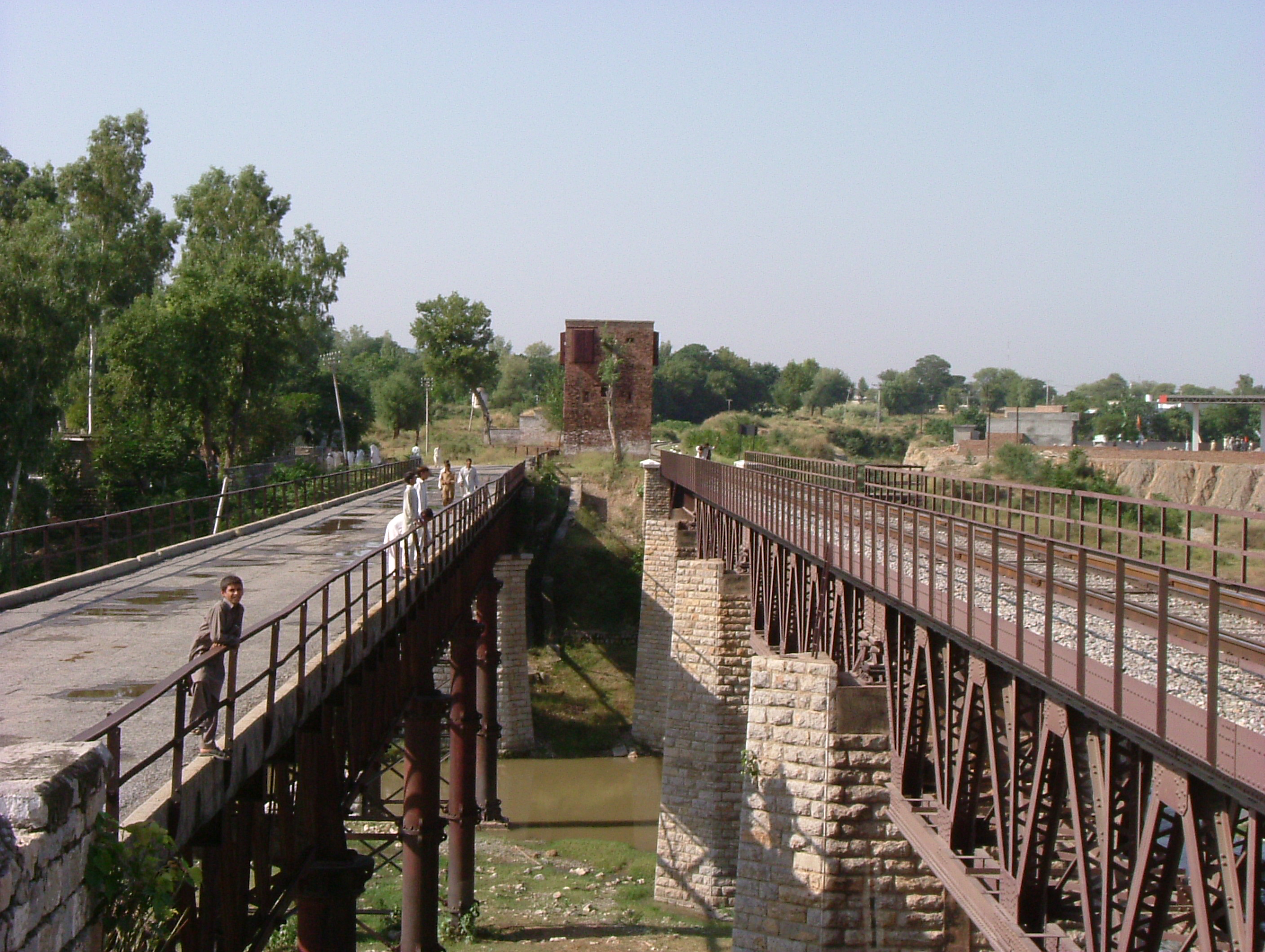 The old Grand Trunk Road and railway bridges crossing the Indus River at Attock, with low rocky hills behind