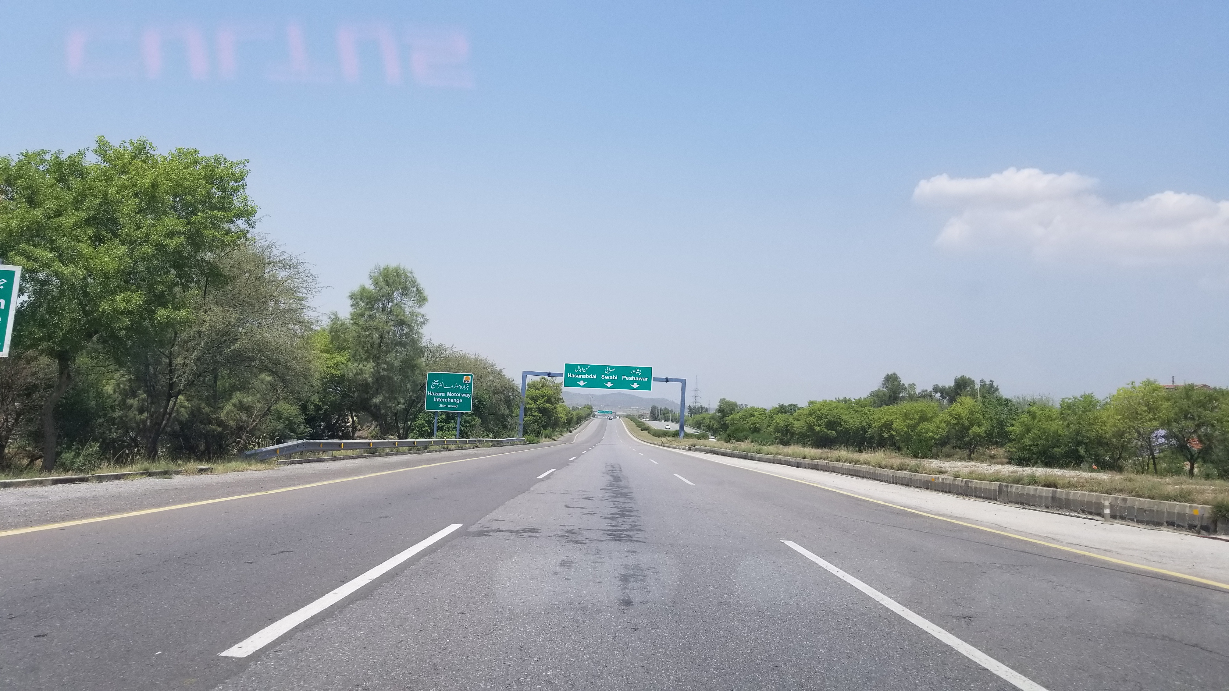 A view of the Islamabad–Peshawar M-1 motorway, showing multiple lanes of the carriageway under a clear sky