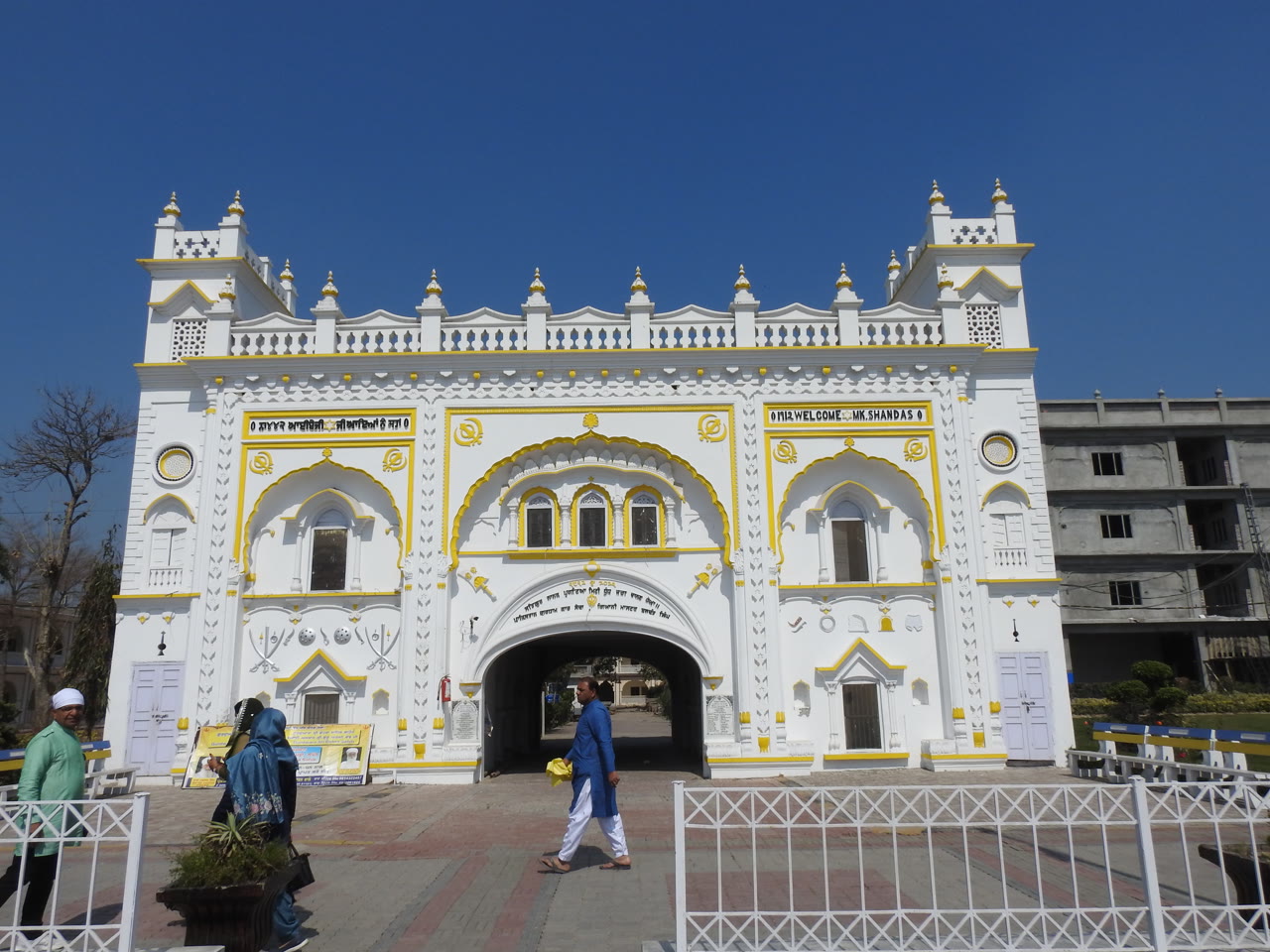 A white-domed gurdwara with a reflecting pool in front of it.