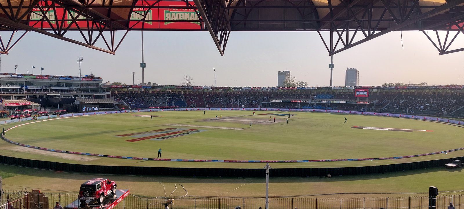 A packed cricket stadium under floodlights during a day-night match