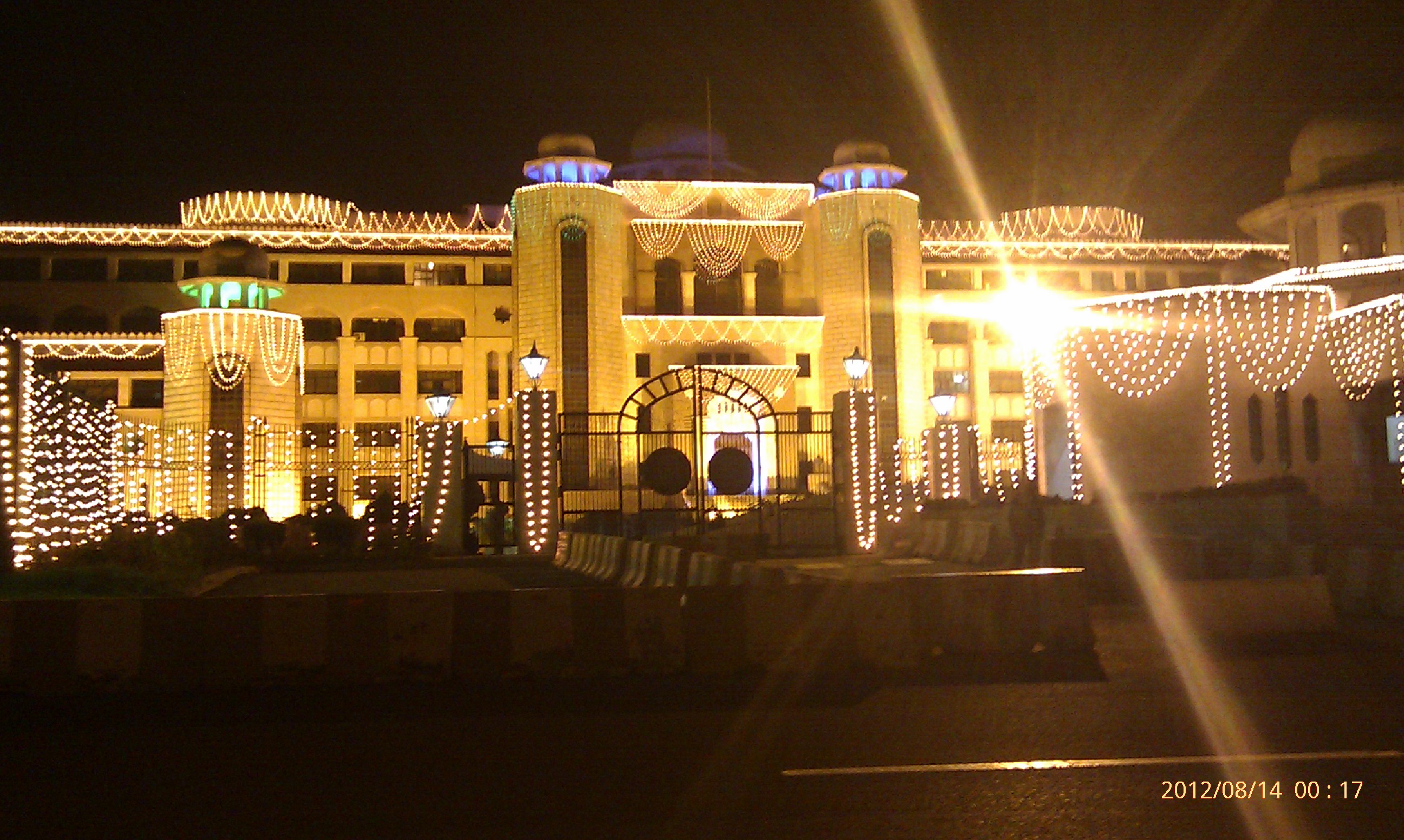 The Prime Minister's Secretariat building in Islamabad, a large white government complex with a tall central block and rows of dark windows.