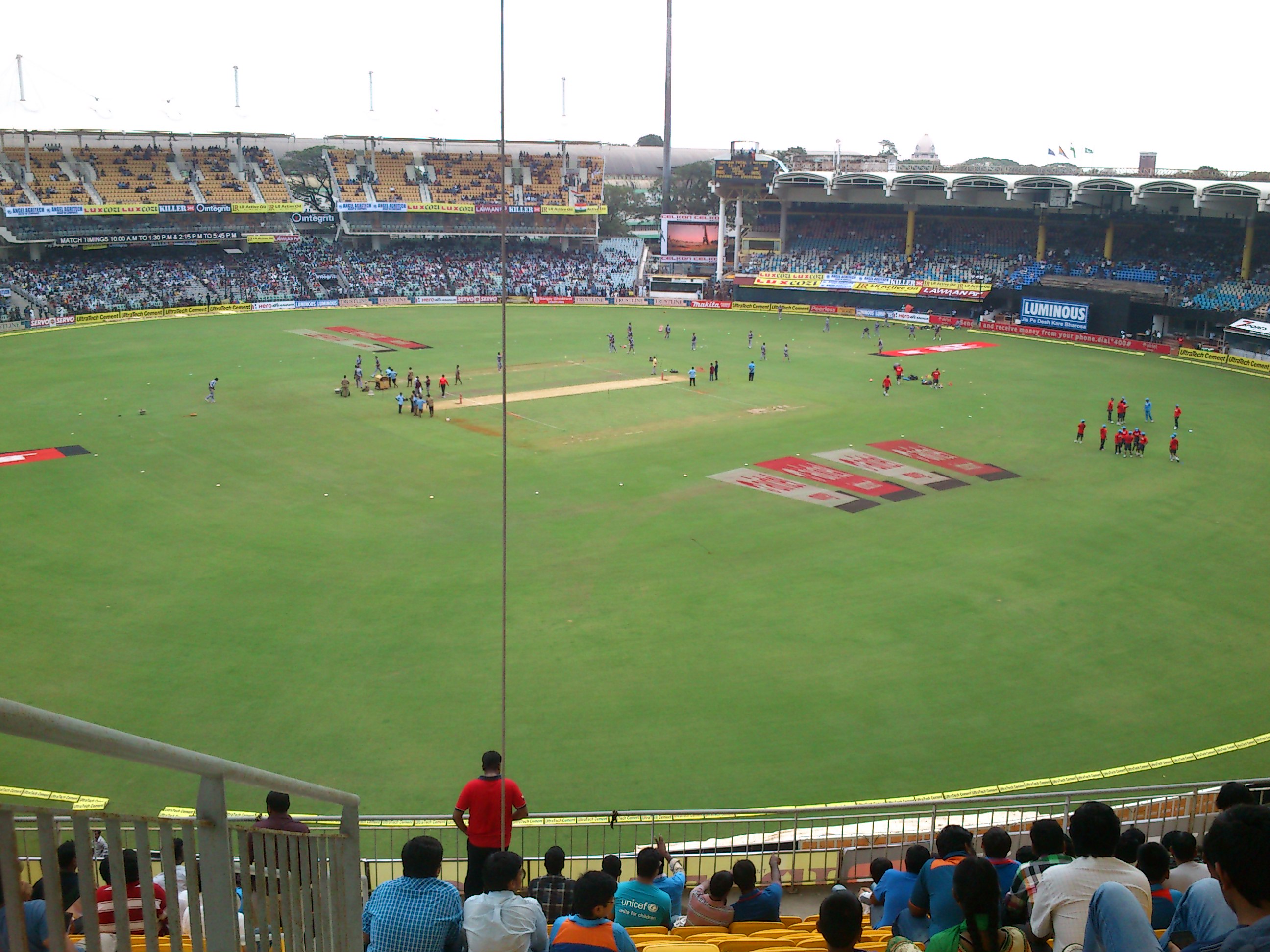 Floodlit panorama of a cricket stadium during an India-Pakistan one-day international, with the pitch and outfield in the foreground