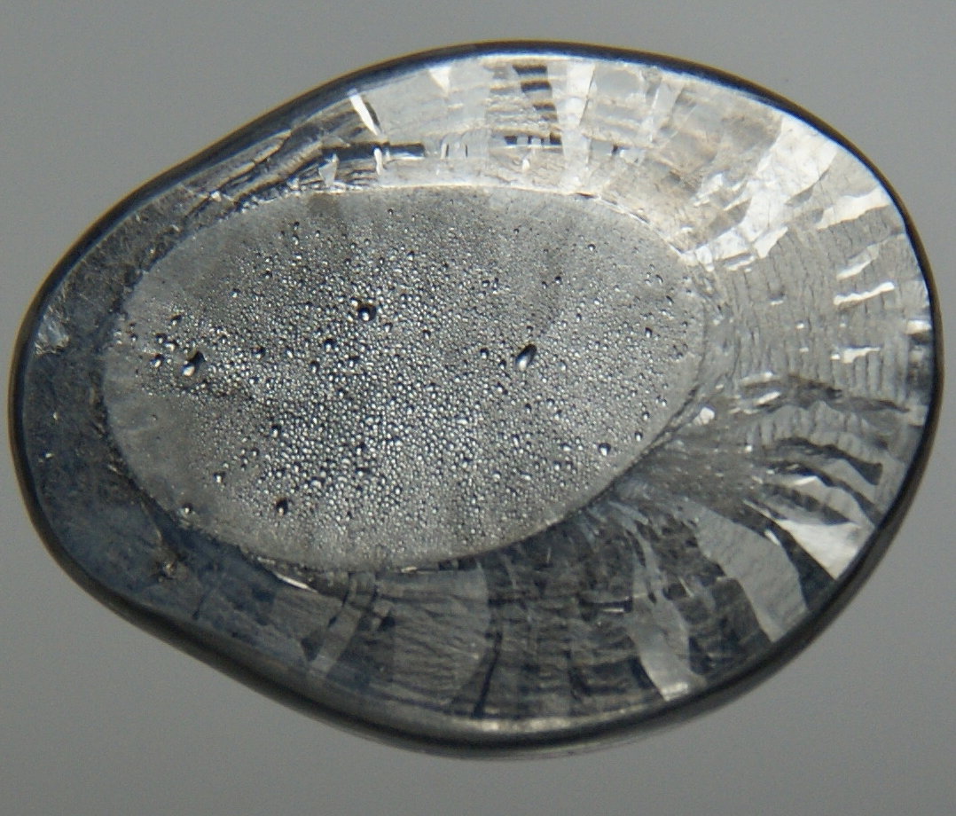 A dark grey lump of metallic lead displayed against a plain background