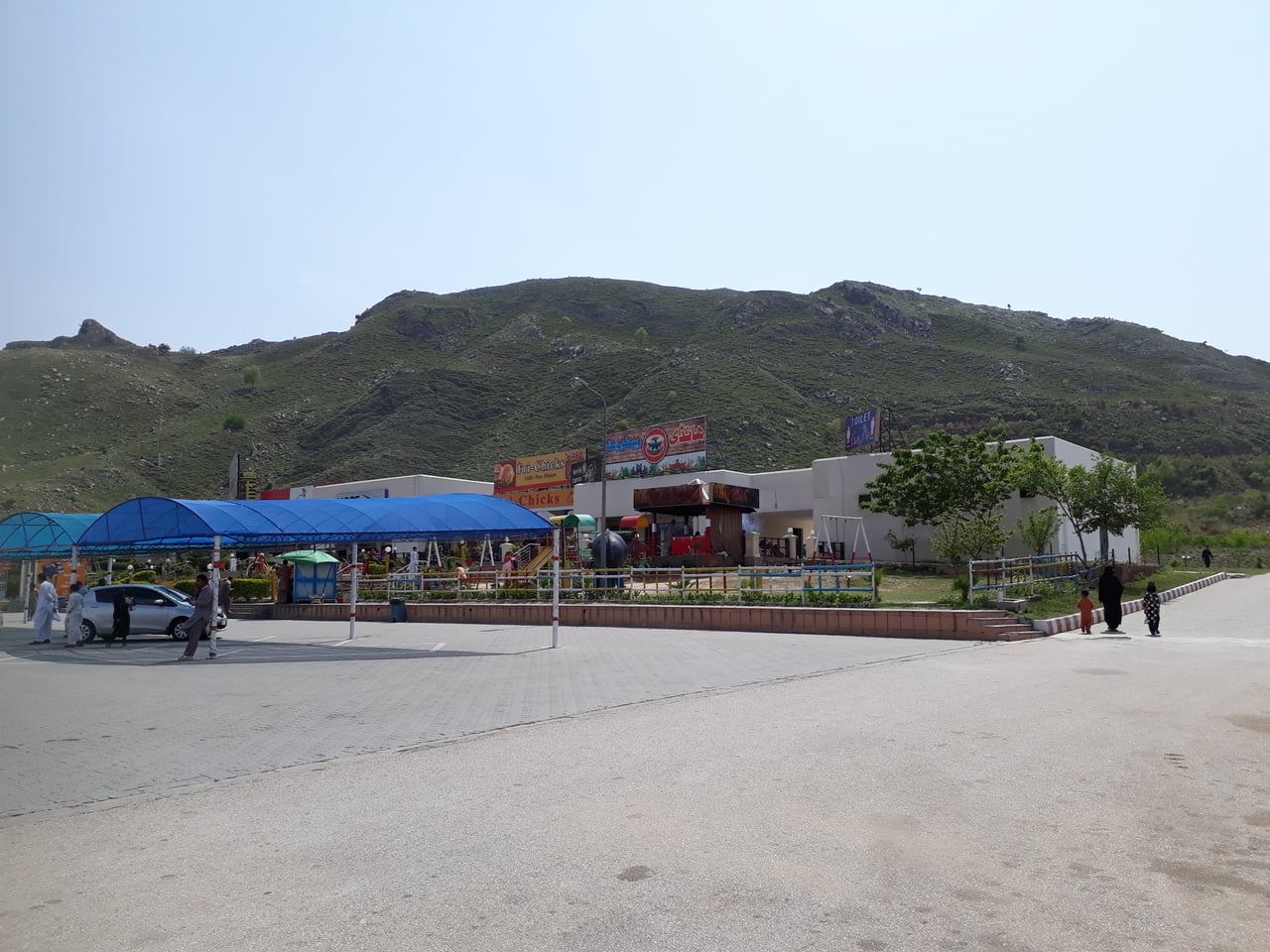 A motorway service station in Pakistan with a wide canopy, fuel pumps and a car parked in front
