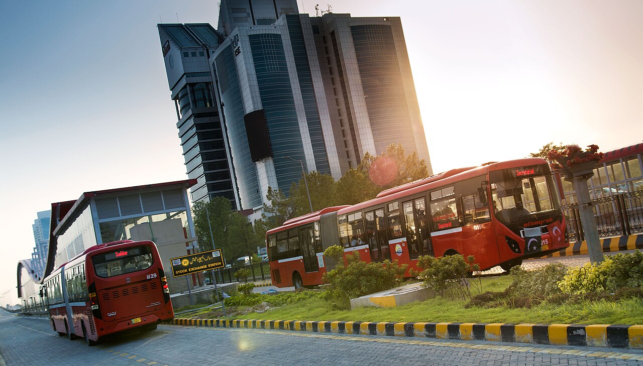 A red Islamabad Metro Bus at a stop in the Blue Area of the capital.