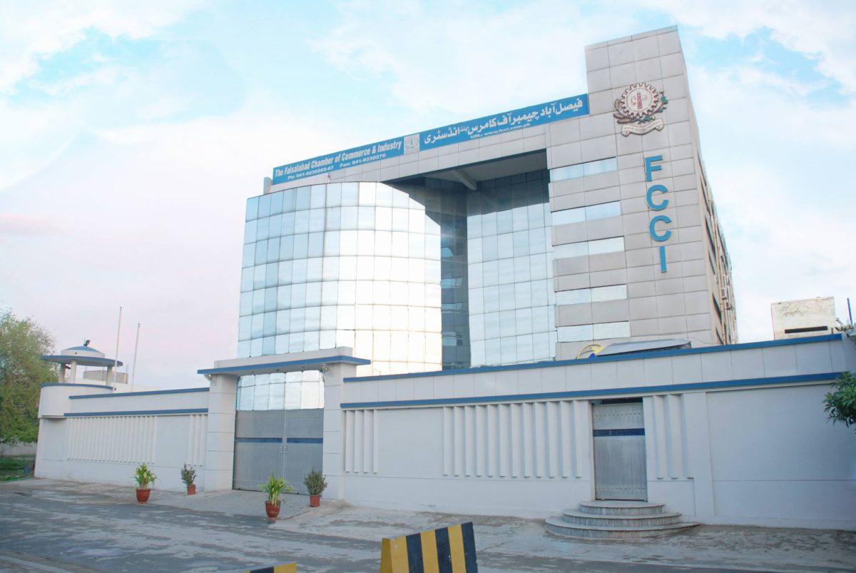 The Faisalabad Chamber of Commerce and Industry building, a modern glass-fronted structure carrying the FCCI sign and lettering
