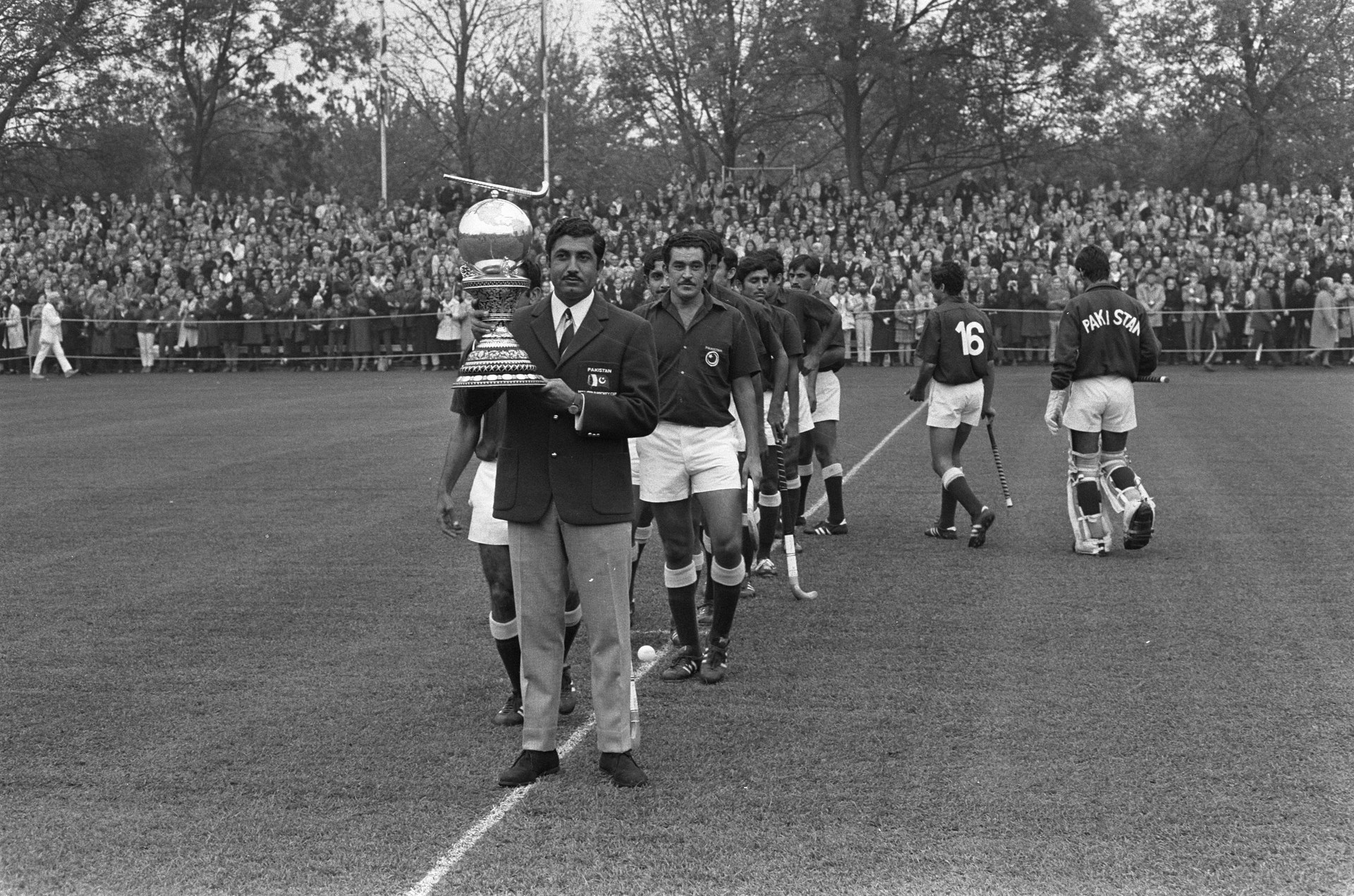 Pakistan and Netherlands hockey players contest the ball during a match.
