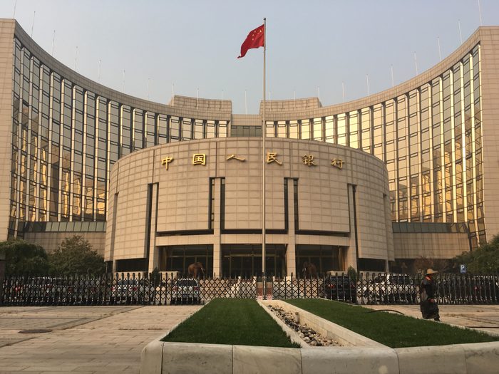 The People's Bank of China headquarters, a tall curved tower, seen from a street in Beijing.