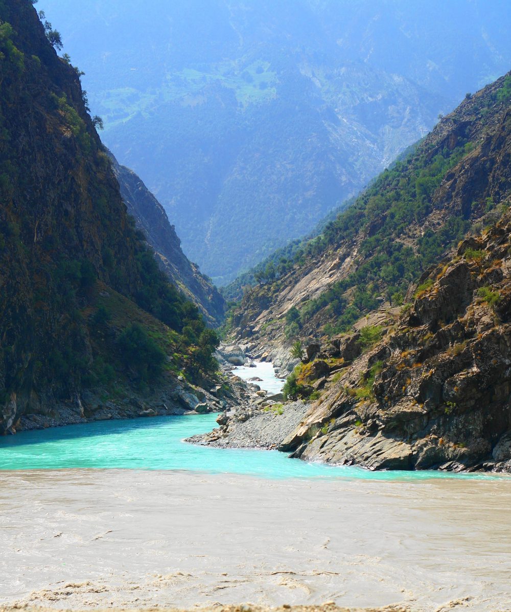 A blue tributary stream mixing with the muddy brown water of the Indus River near Chilas in northern Pakistan.