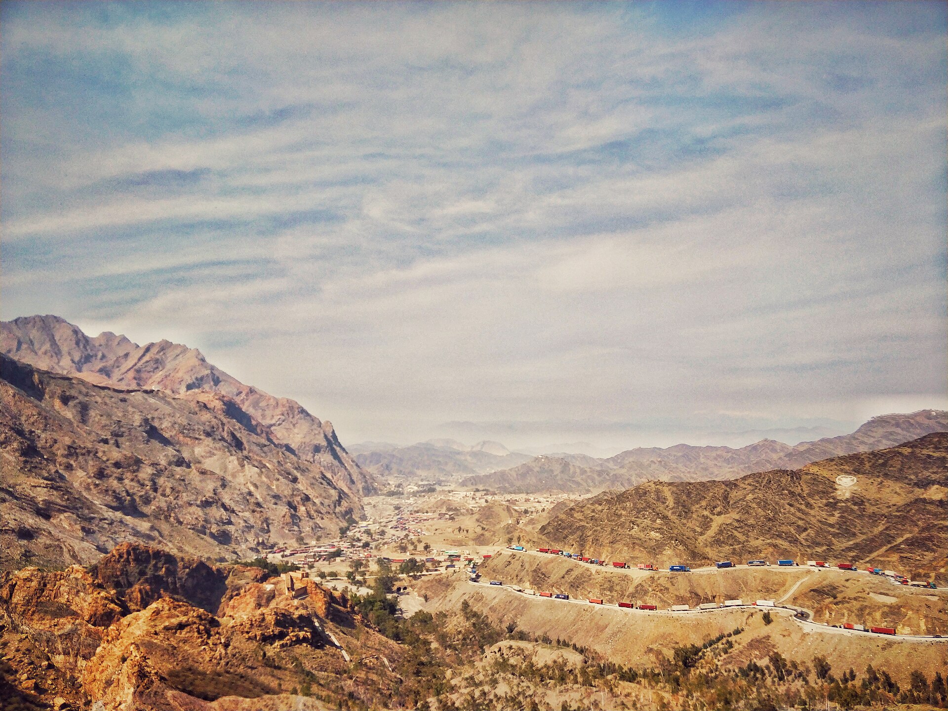 A mountain highway winding toward the Torkham border crossing between Pakistan and Afghanistan.