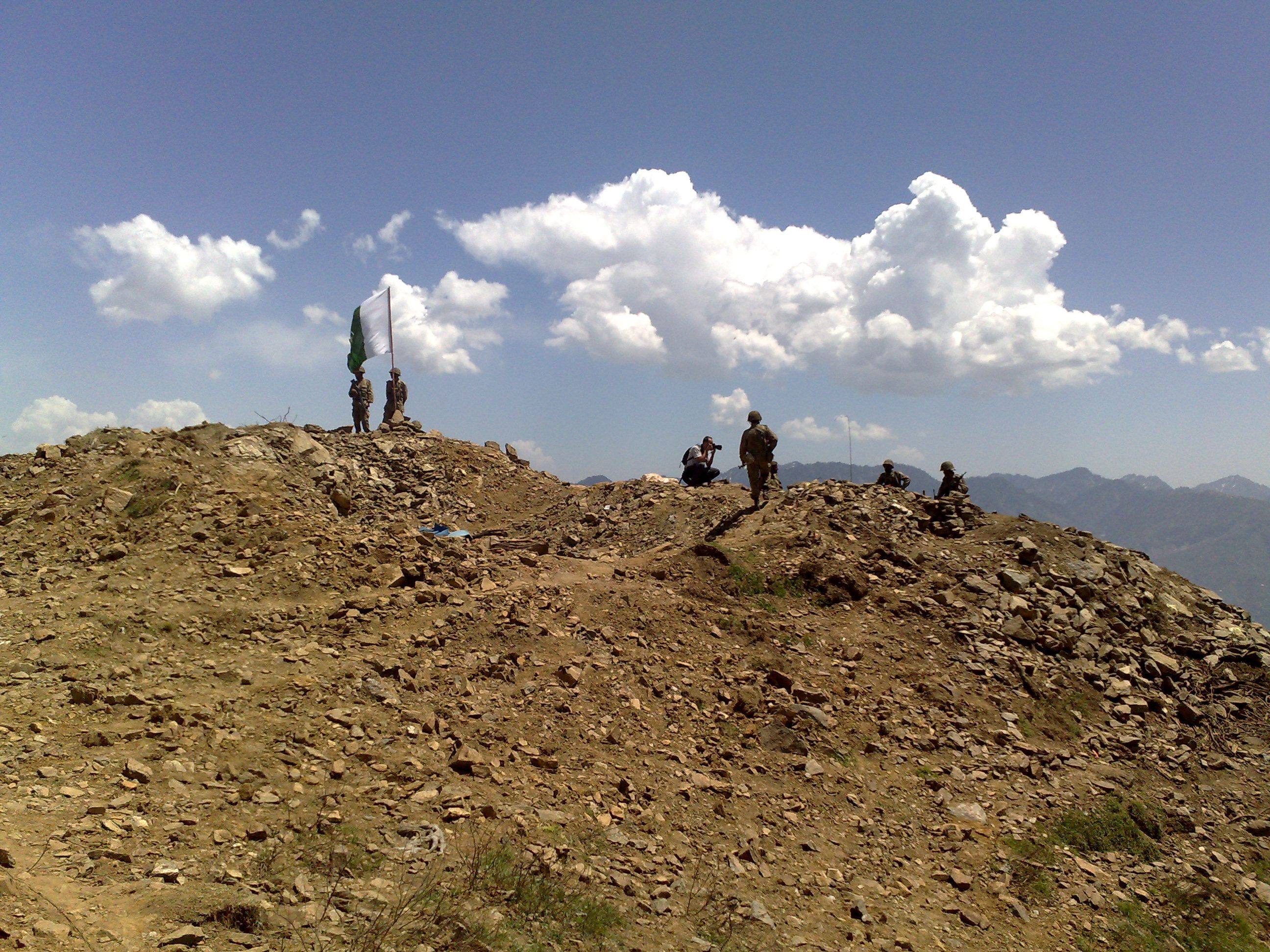 Pakistani soldiers in combat gear pose for the camera in a mountainous setting in Swat