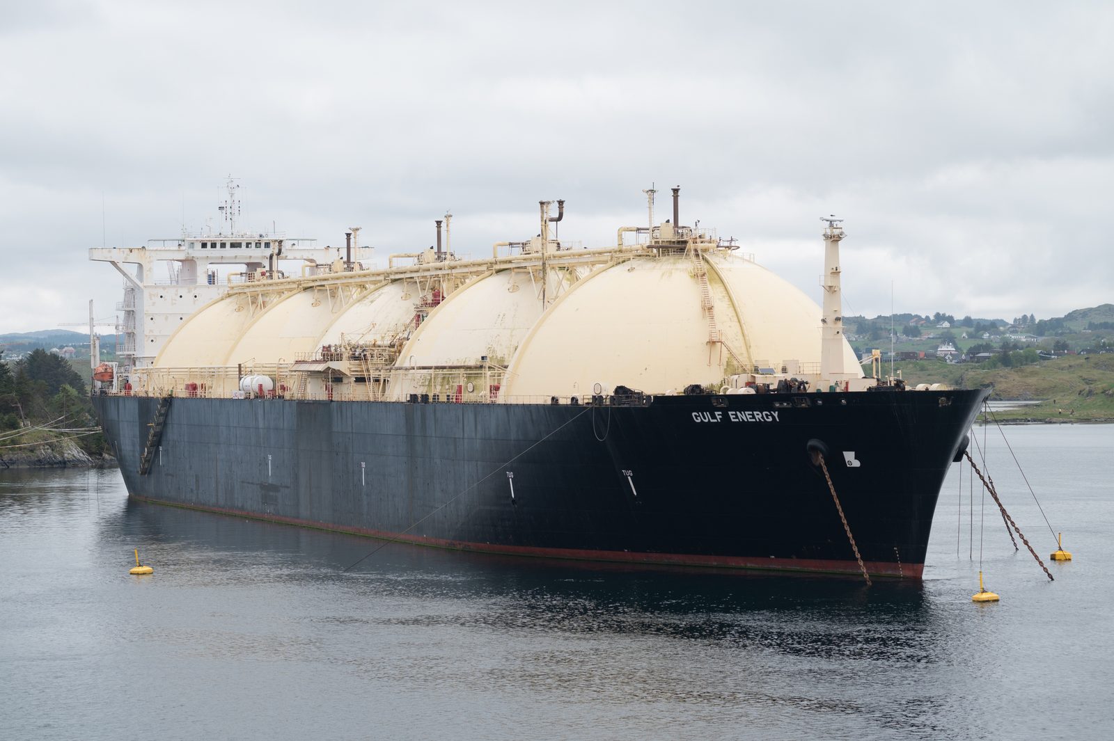 An LNG carrier at sea with its four spherical Moss-type cargo tanks visible above deck.