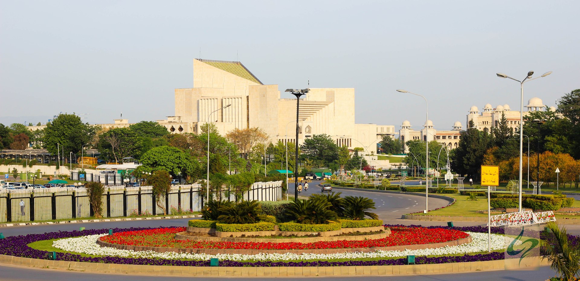 Parliament House in Islamabad seen from the flower-bed roundabout at the D-Intersection on Constitution Avenue, with the Presidential Secretariat complex to the right.