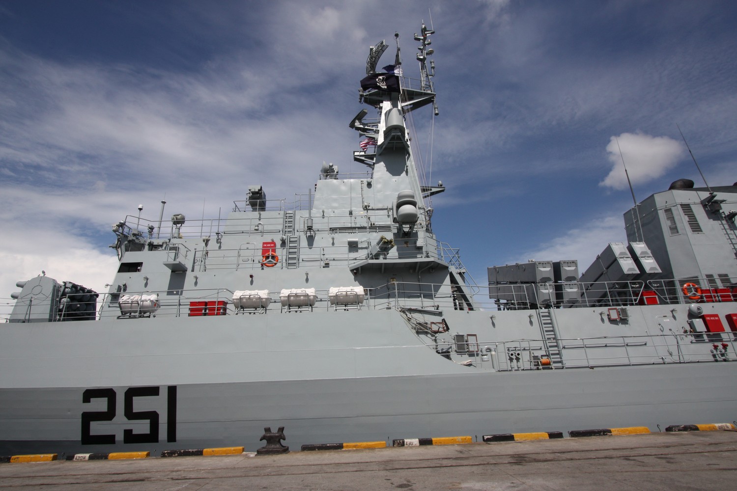The grey hull and superstructure of the Pakistan Navy frigate PNS Zulfiquar, seen from the side while moored in port
