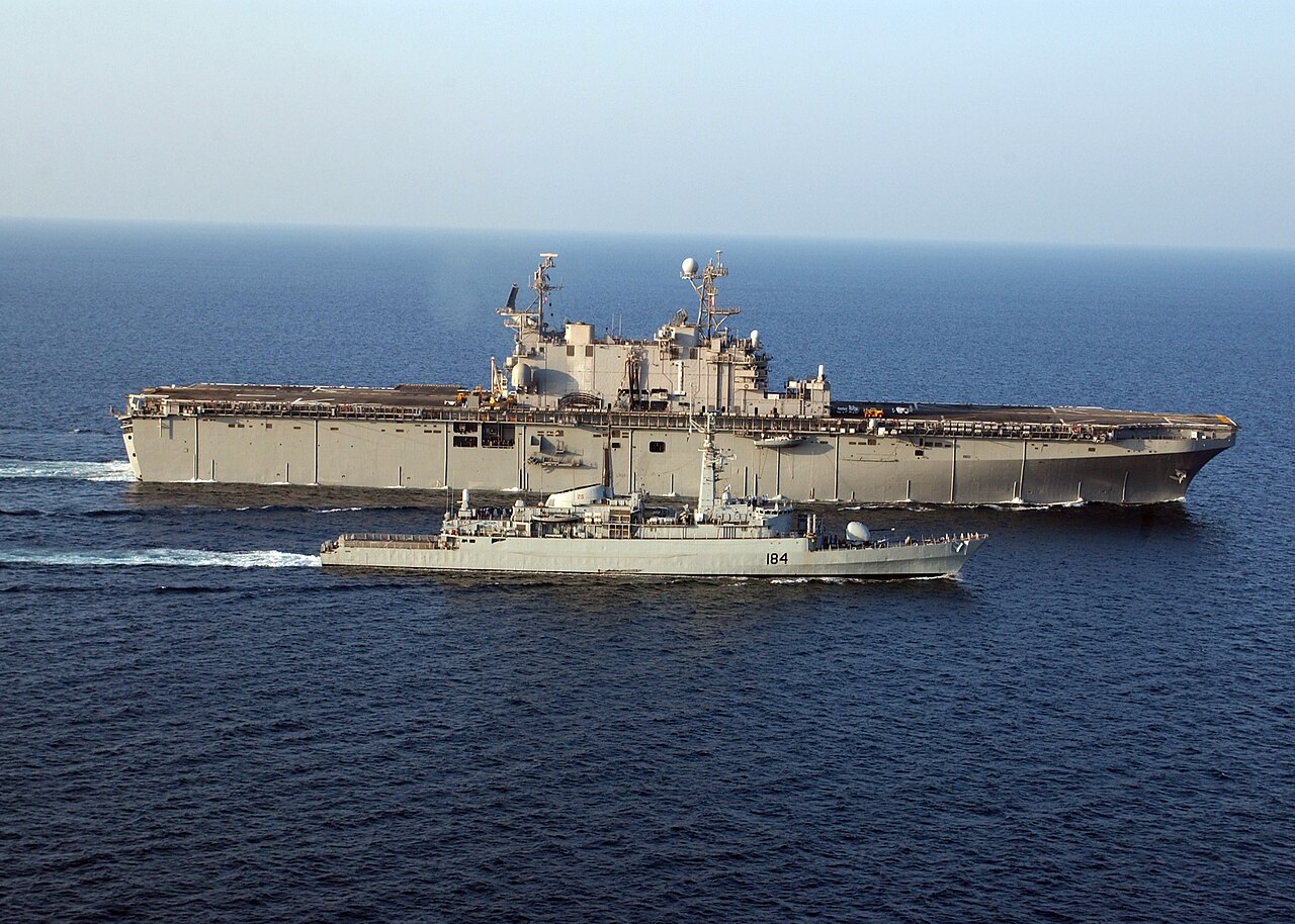 The Pakistani Navy frigate PNS Badr steams alongside a larger vessel in open water
