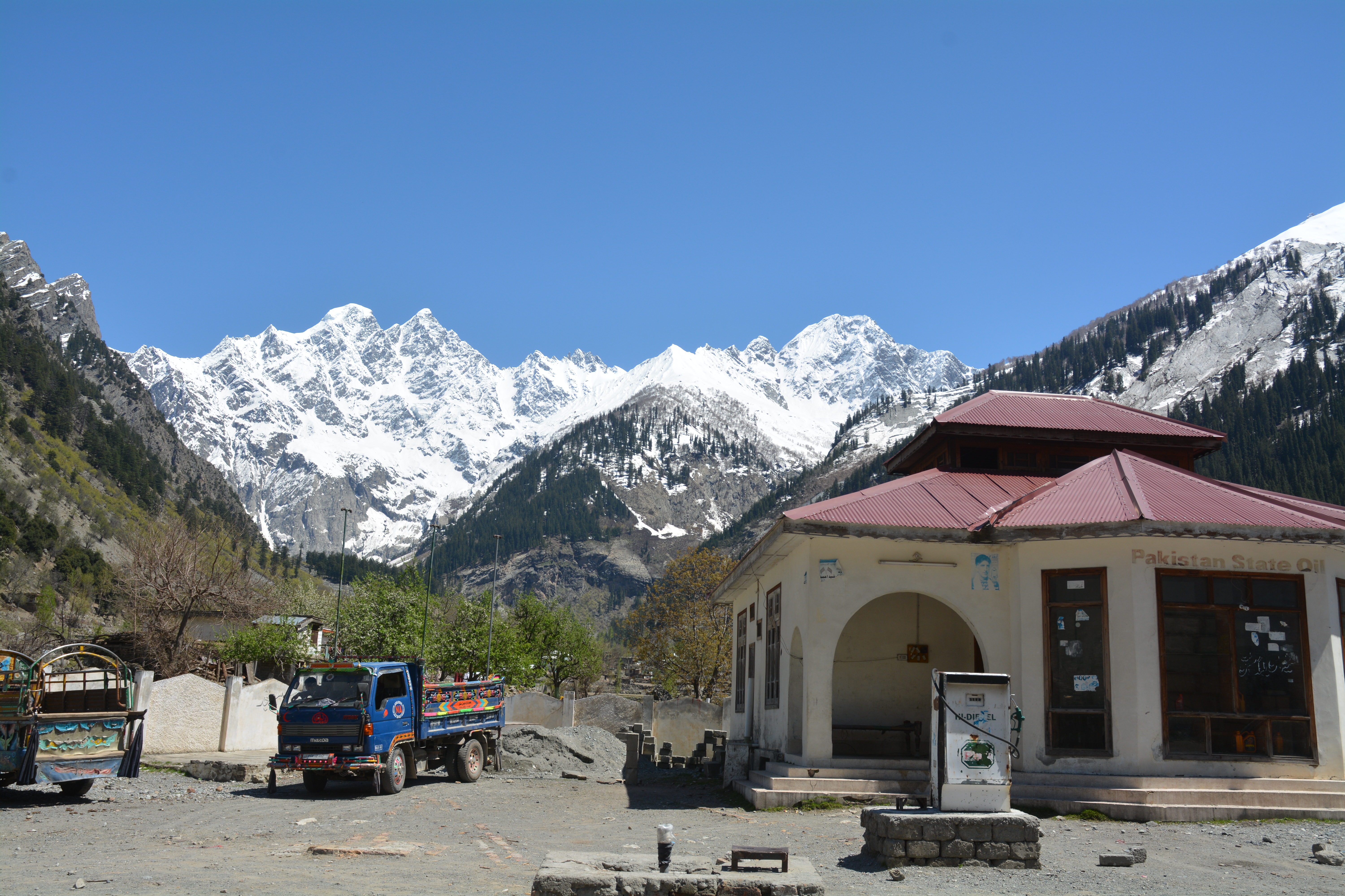 A Pakistan State Oil petrol pump in the mountains of Kalam in the Swat Valley, with a fuel canopy and pumps set against a clear sky.