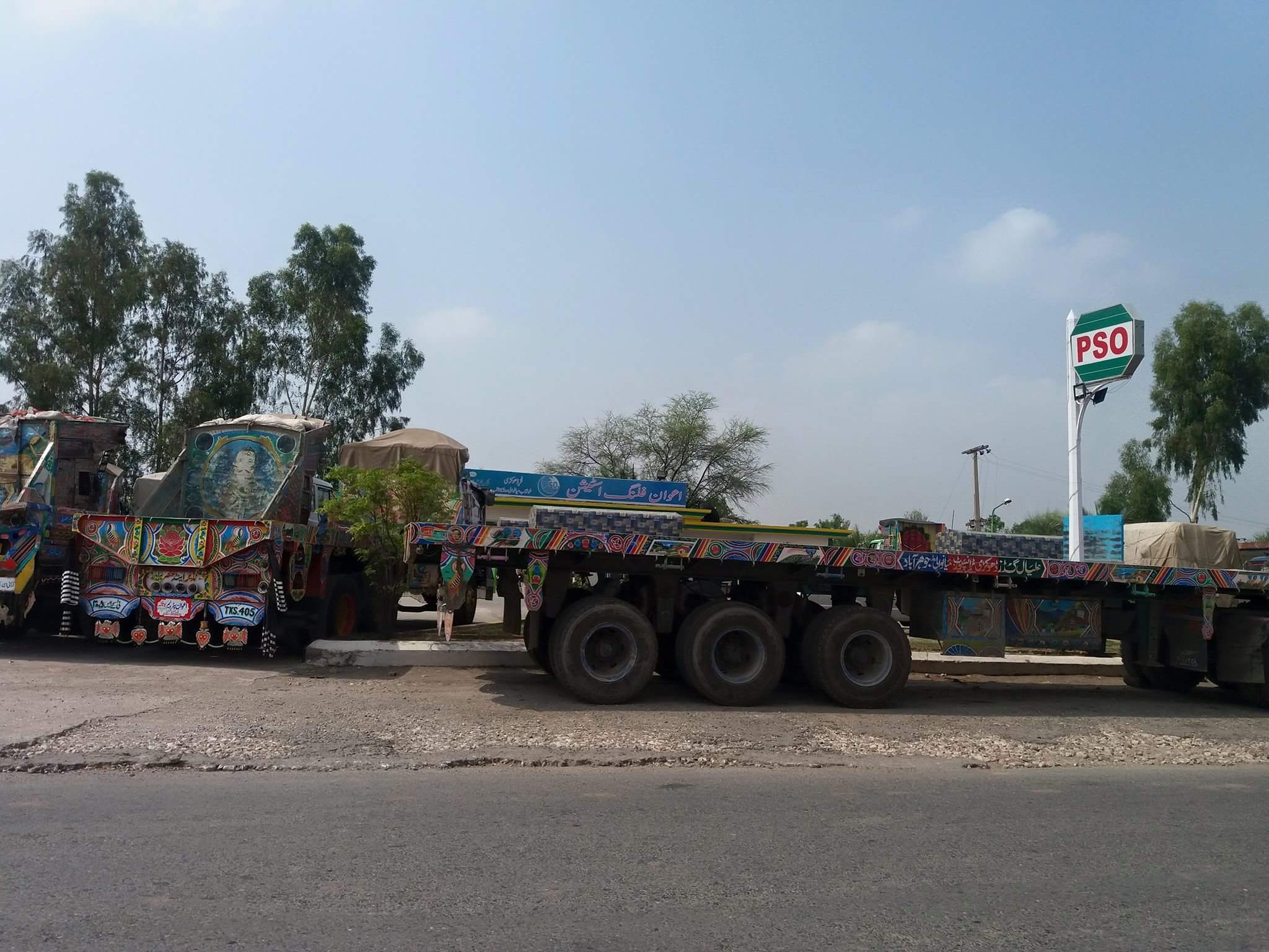 Pakistan State Oil tanker trucks parked alongside a PSO filling station in Punjab, with the green PSO logo visible above the canopy.