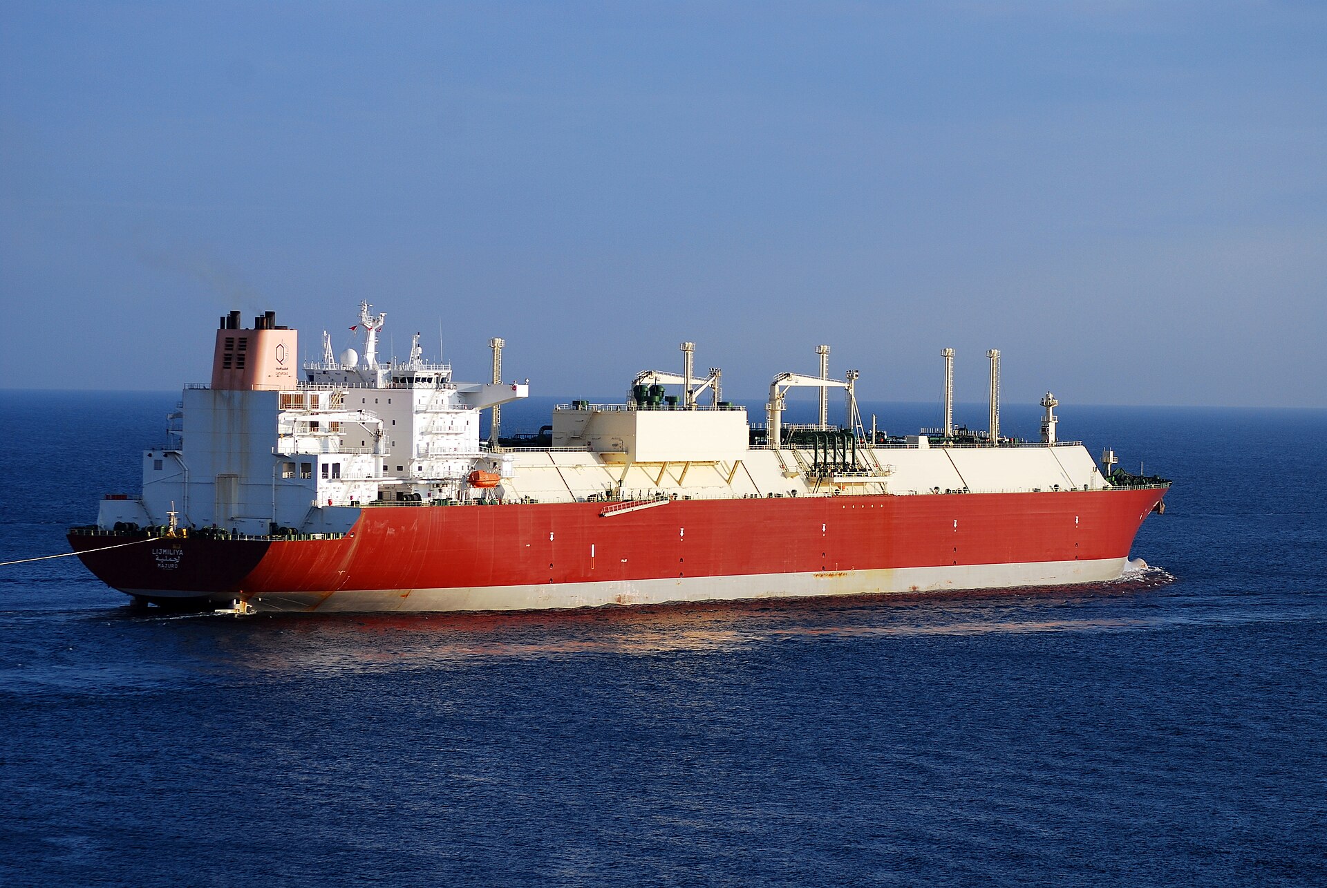 A large QatarGas liquefied natural gas carrier at sea with its storage tanks visible on deck.