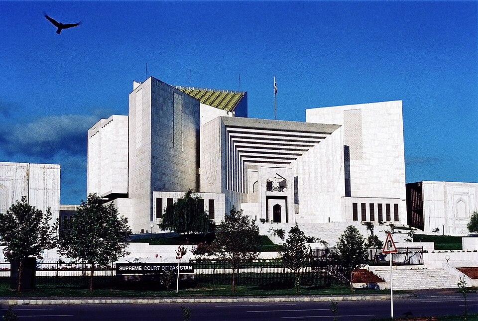 The white marble Supreme Court of Pakistan building in Islamabad, with its green roof and the Supreme Court of Pakistan sign at the entrance.