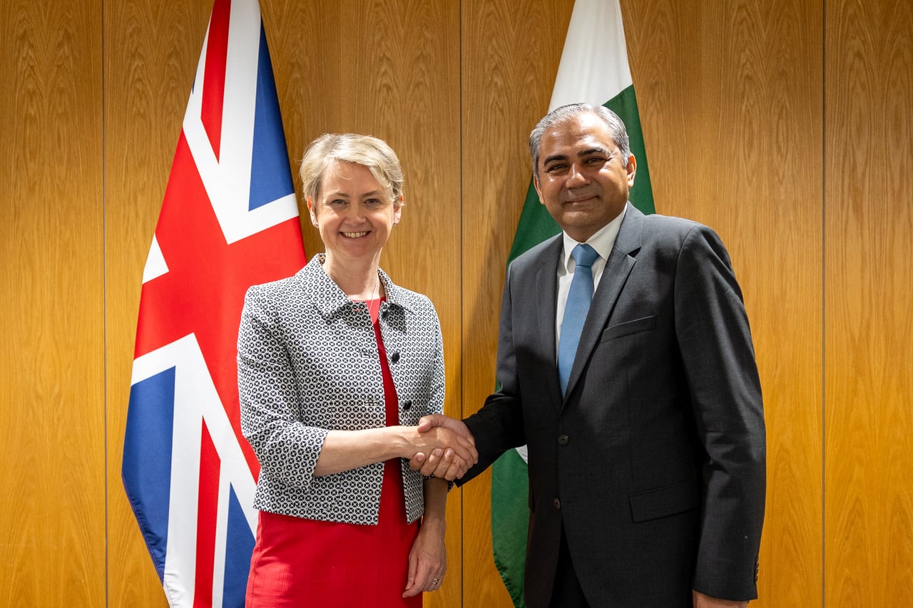 A UK and a Pakistani interior minister seated across a table during a bilateral meeting in London.