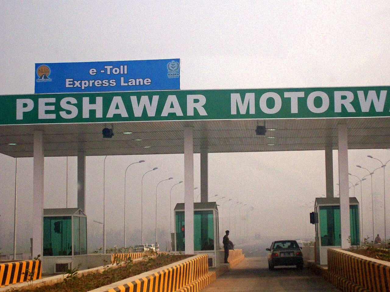The entrance to the Peshawar to Islamabad M-1 motorway near Peshawar, showing toll plazas and road signs.