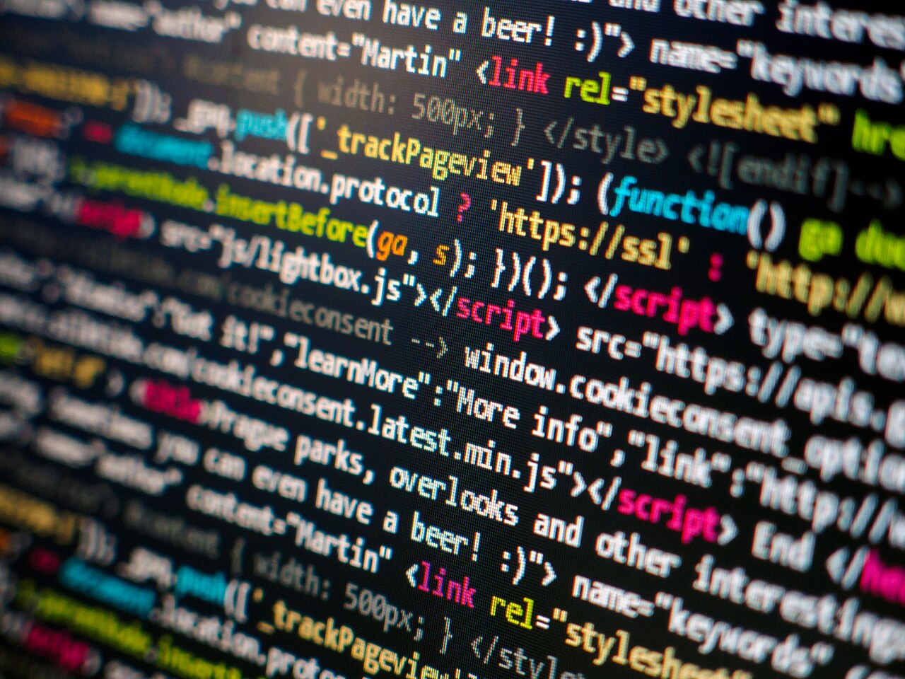 Lines of HTML and JavaScript source code with coloured syntax highlighting on a dark computer display