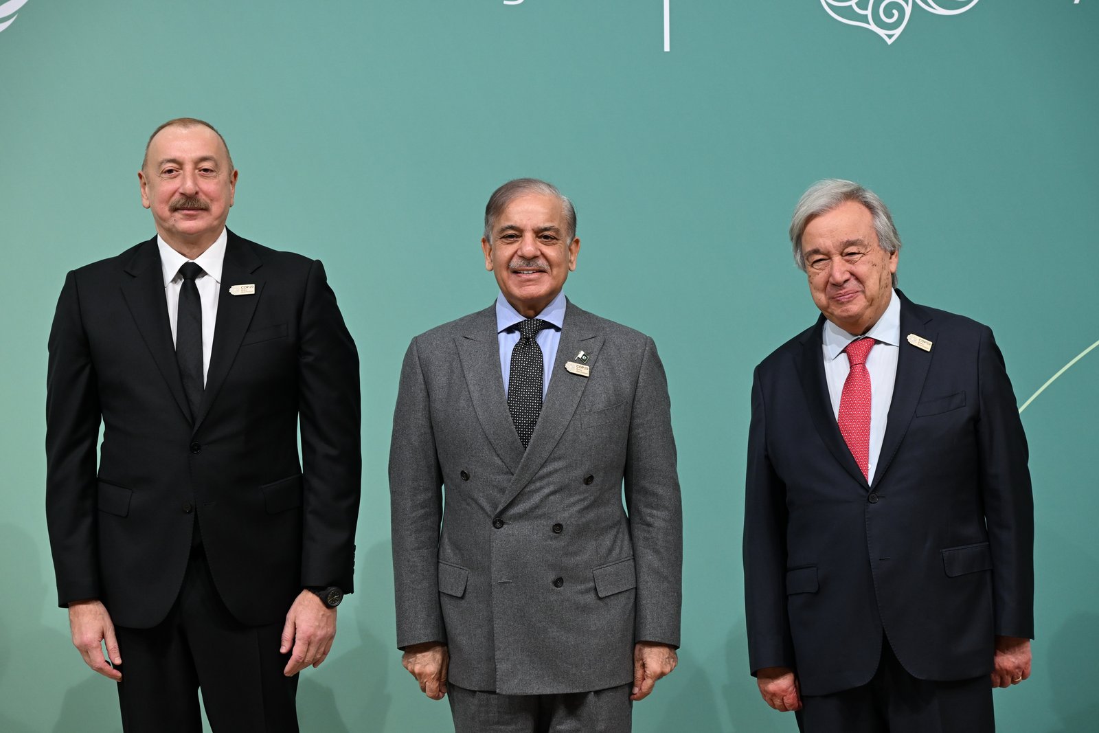 Prime Minister Shehbaz Sharif standing between Azerbaijan's president and the UN secretary-general at a summit backdrop.