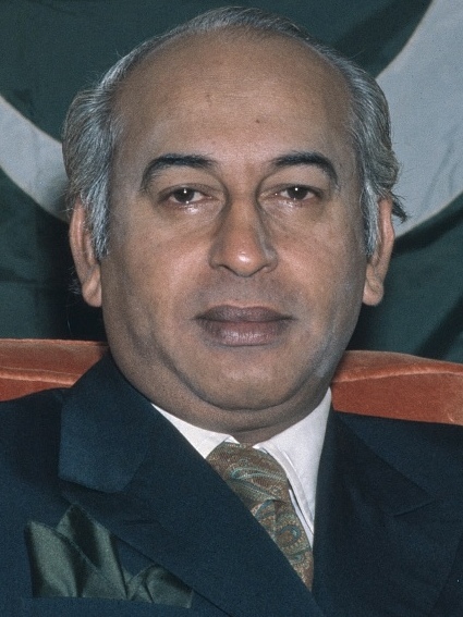 A portrait of Zulfikar Ali Bhutto with a Pakistani flag in the background.