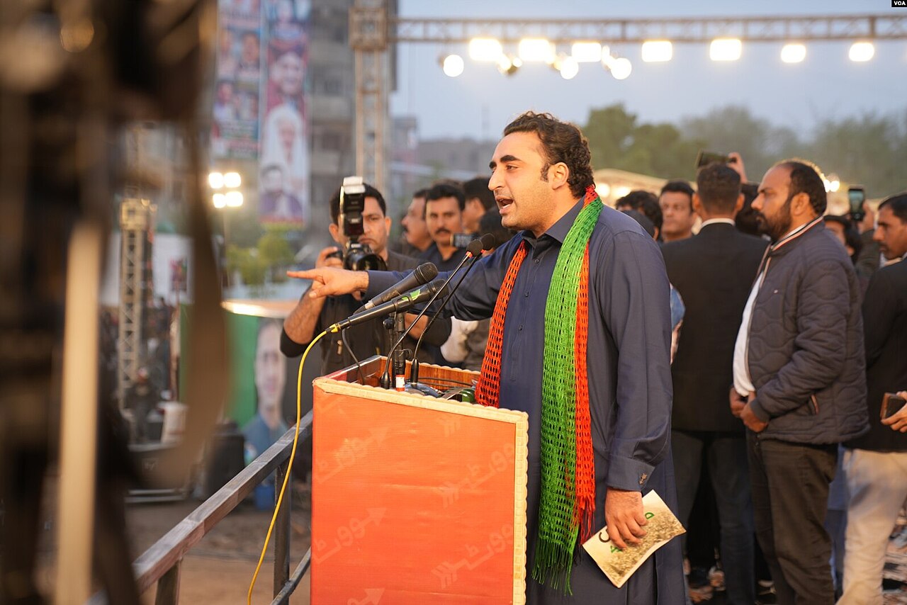 Bilawal Bhutto-Zardari in a dark shalwar kameez speaking at a podium, with a plain background behind him.