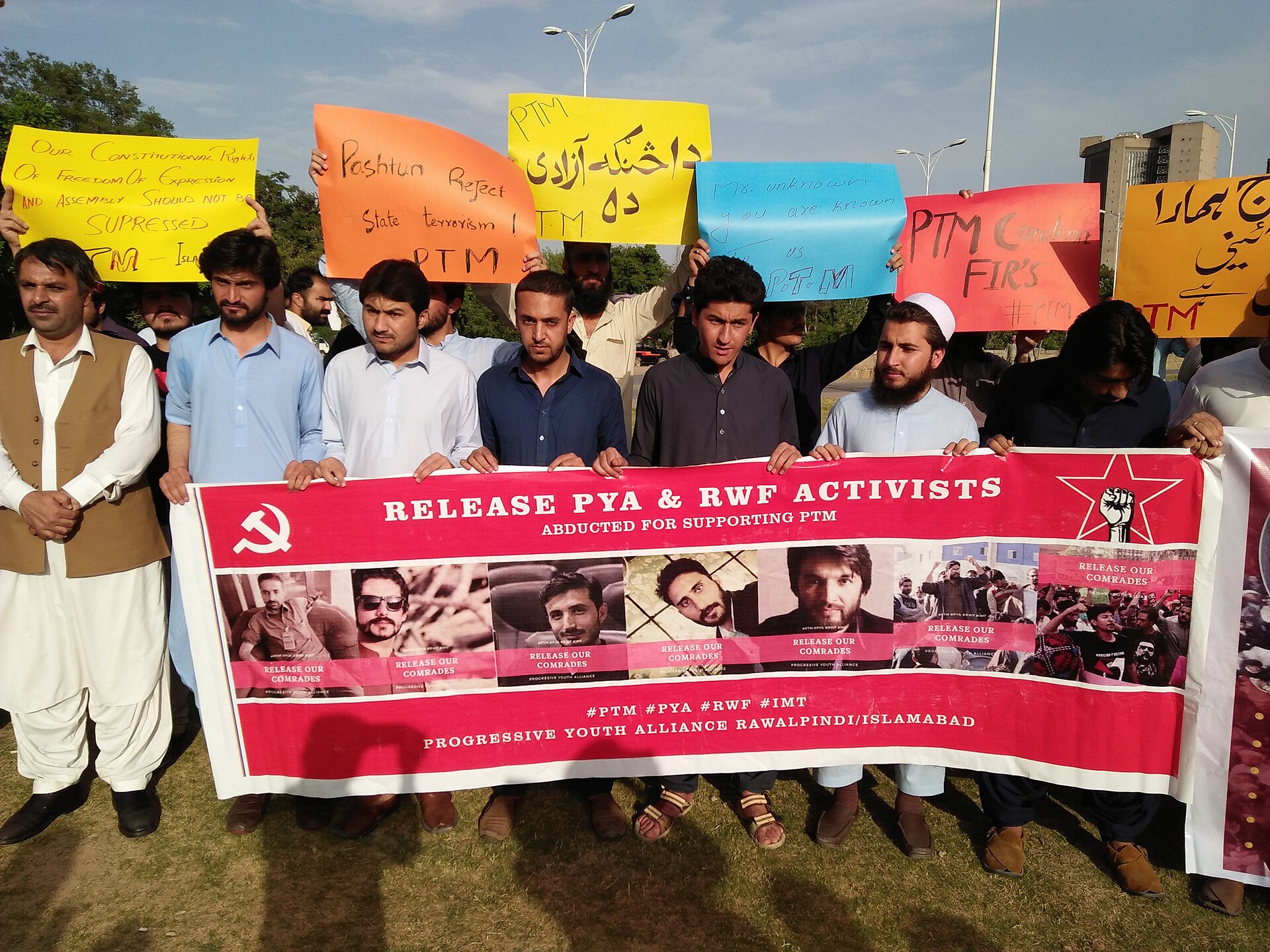 A crowd of protesters at a street rally in Islamabad, photographed from behind the gathered supporters