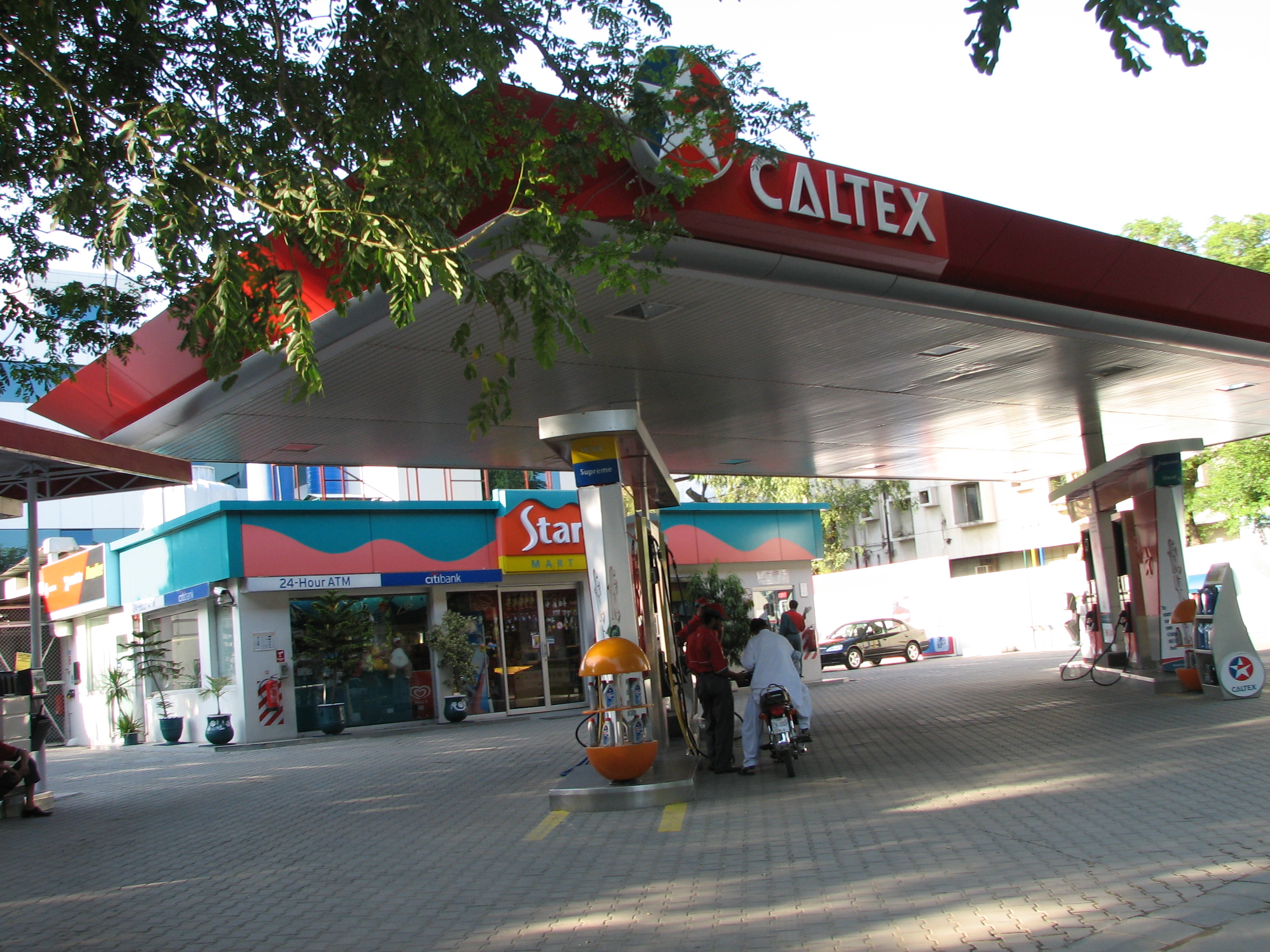 Petrol pumps under a canopy at a Caltex filling station beside a road in Islamabad.