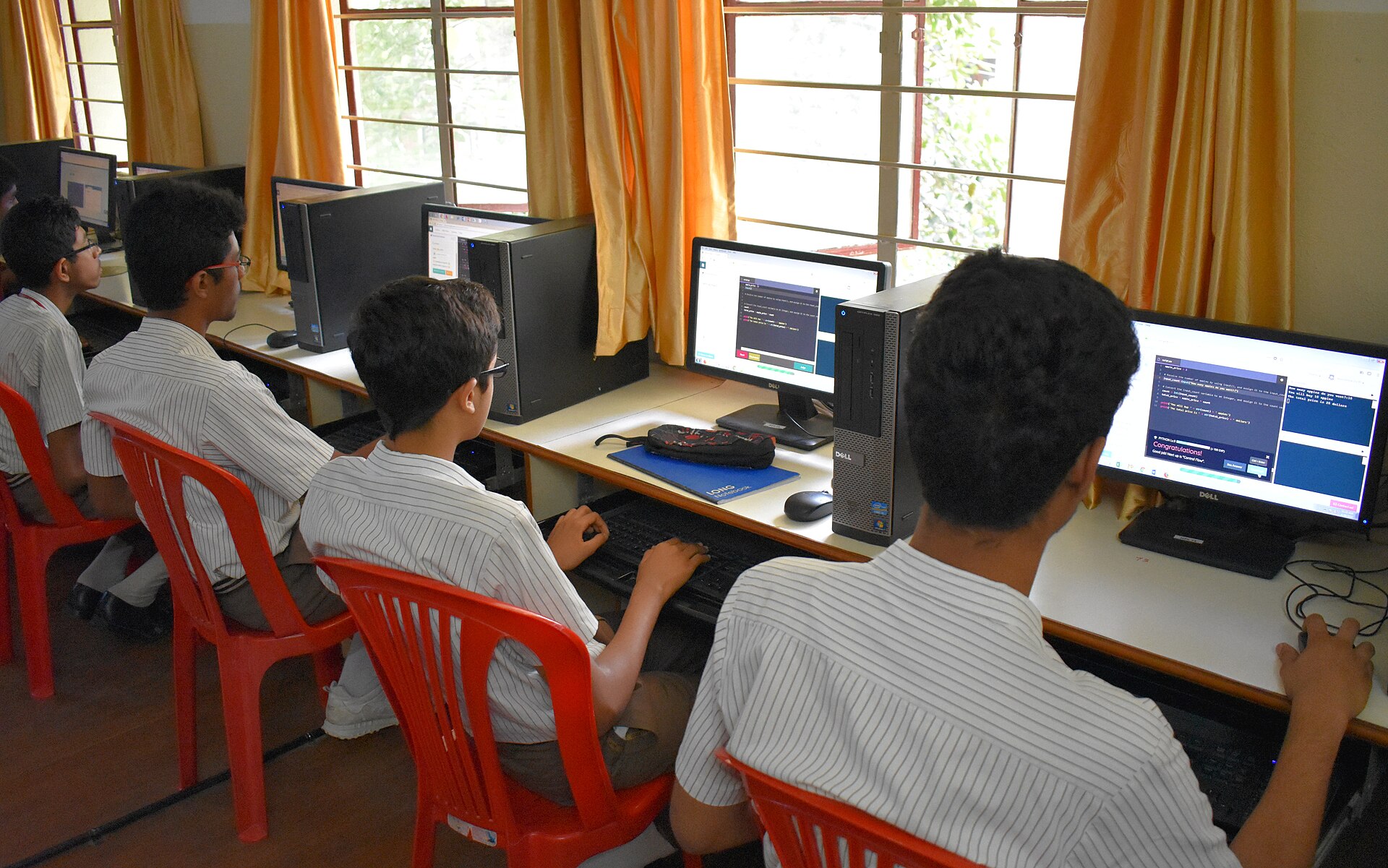School students working at computers during a coding lesson in a classroom
