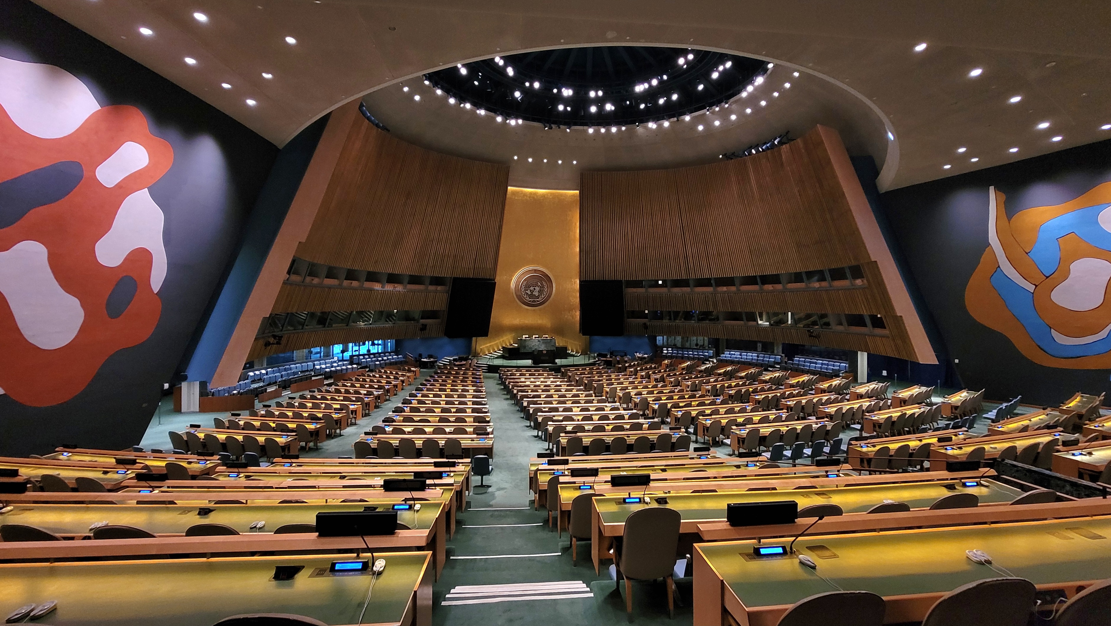 Interior of the United Nations General Assembly hall in New York, showing rows of seats and the green marble podium