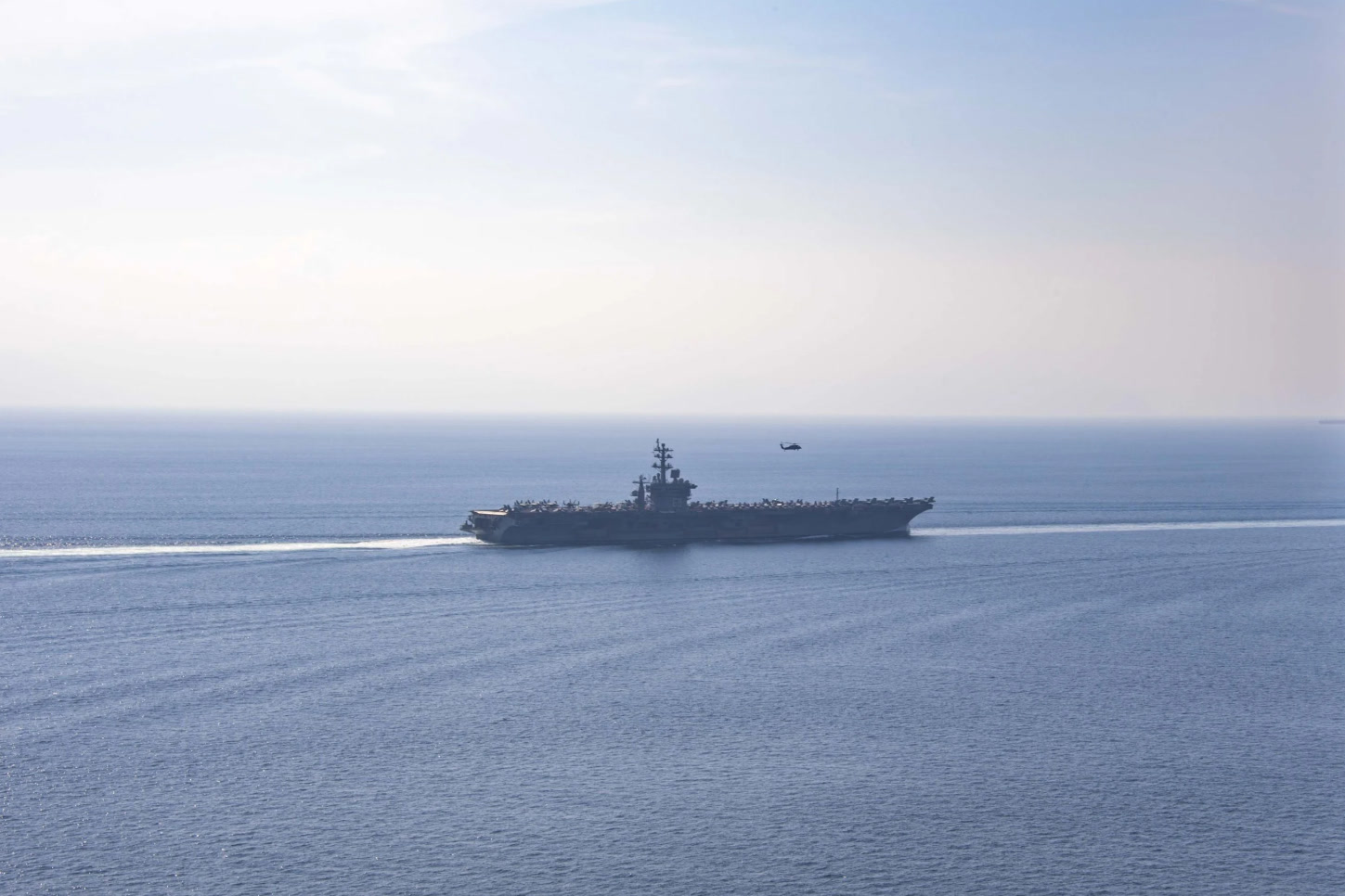 The US Navy aircraft carrier USS Dwight D. Eisenhower transits the Strait of Hormuz with an escort vessel alongside